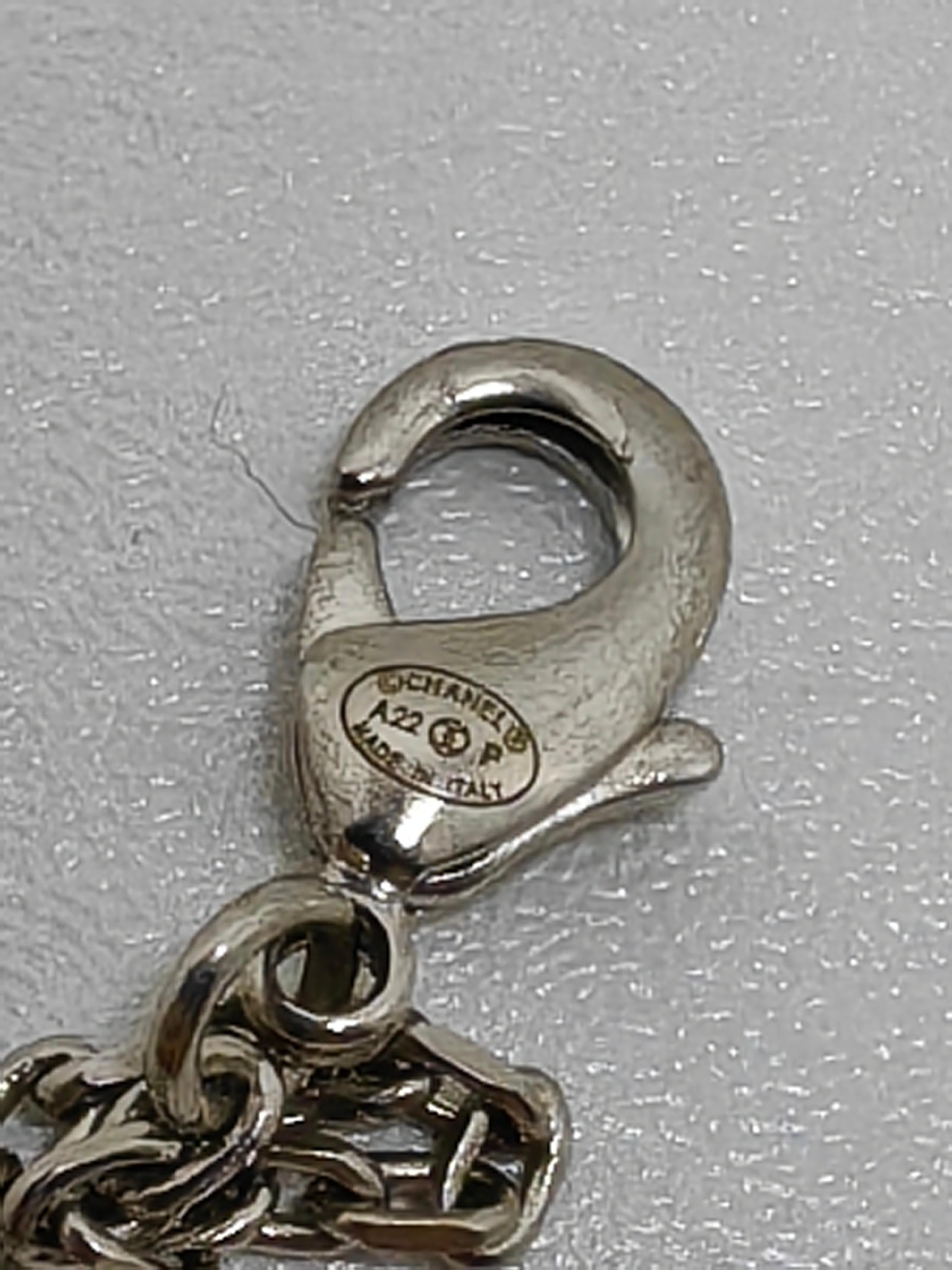 Aggiungi un tocco di lusso al tuo guardaroba con la collana con ciondolo con strass CC di Chanel A22, con una sorprendente finitura argentata. Questa splendida collana sfoggia il doppio logo 