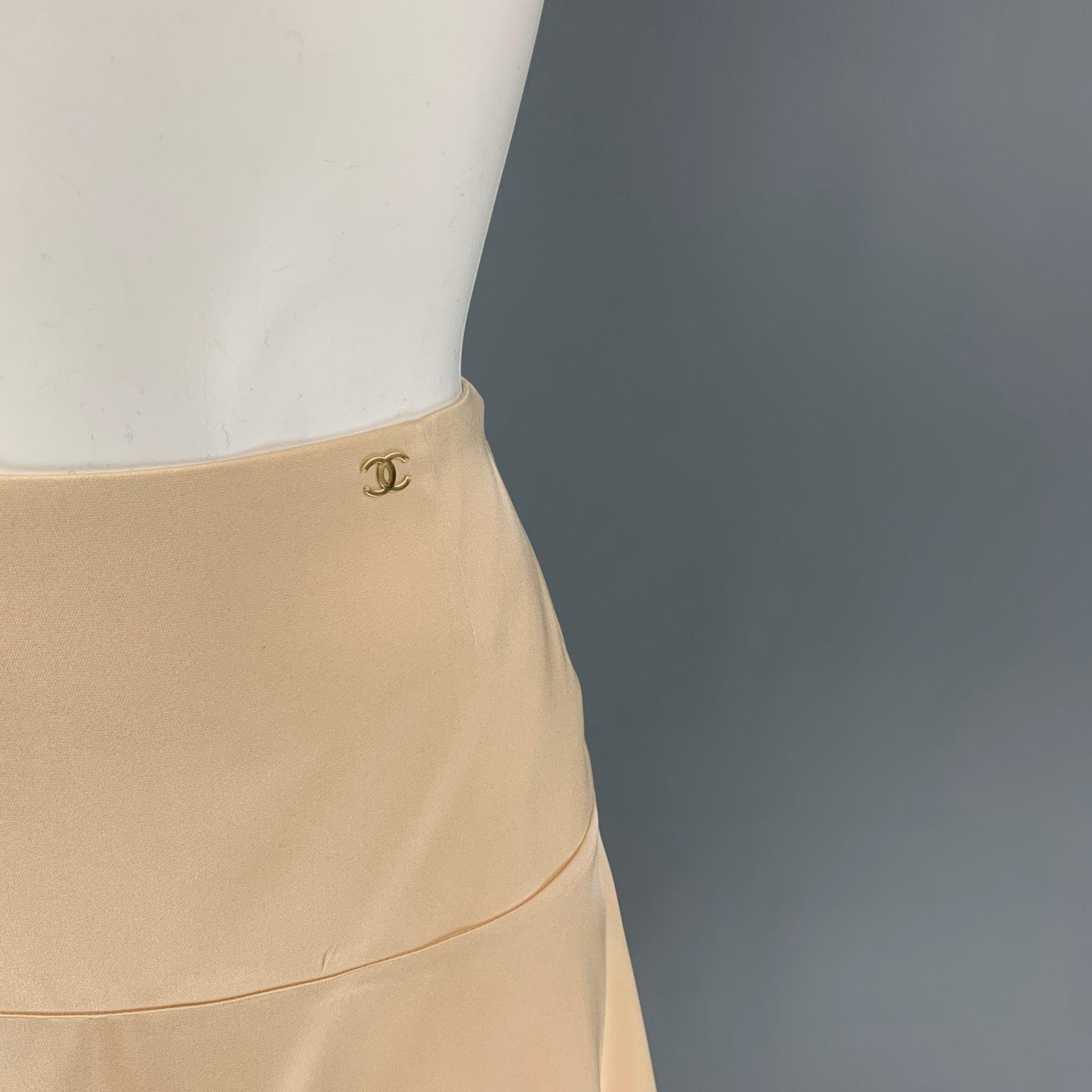 CHANEL skirt comes in a champagne silk featuring a layered style, gold tone logo detail, and a back zip up closure. Made in France.
Very Good
Pre-Owned Condition. 

Marked:   AI098 034 / 38 

Measurements: 
  Waist:
28 inches  Hip: 40 inches 