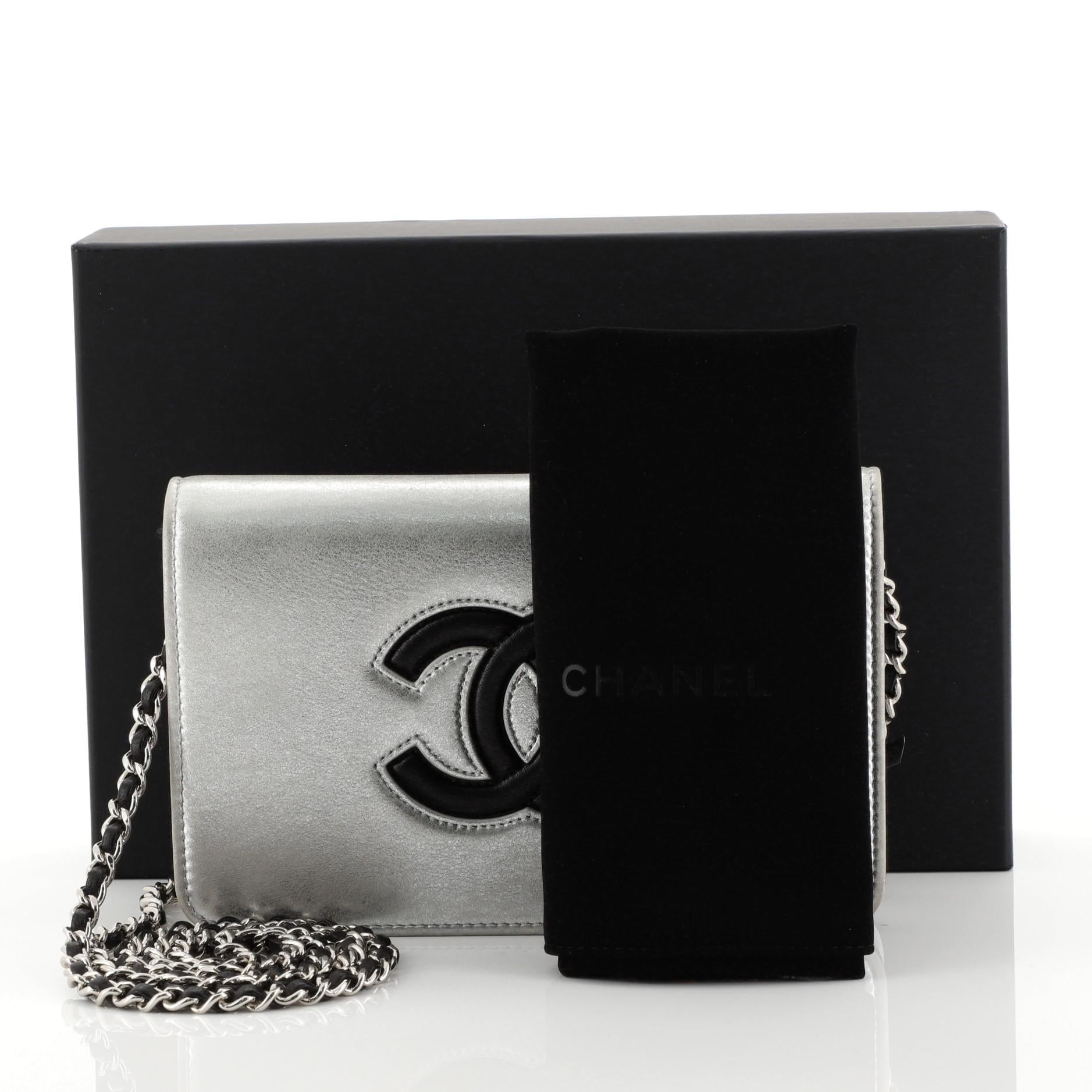 This Chanel Airlines CC Wallet on Chain Calfskin, crafted from metallic silver calfskin leather, features woven-in leather chain strap, stitched CC interlocking logo, and silver-tone hardware. Its snap button closure opens to a black leather and