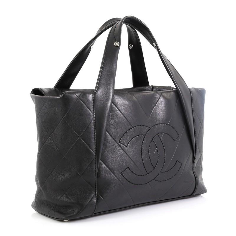 This Chanel All Day Long Tote Chevron Leather Medium, crafted from black chevron quilted leather, features dual flat handles, stitched CC logo at front, and silver-tone hardware. Its top zip closure opens to a black fabric interior with side zip