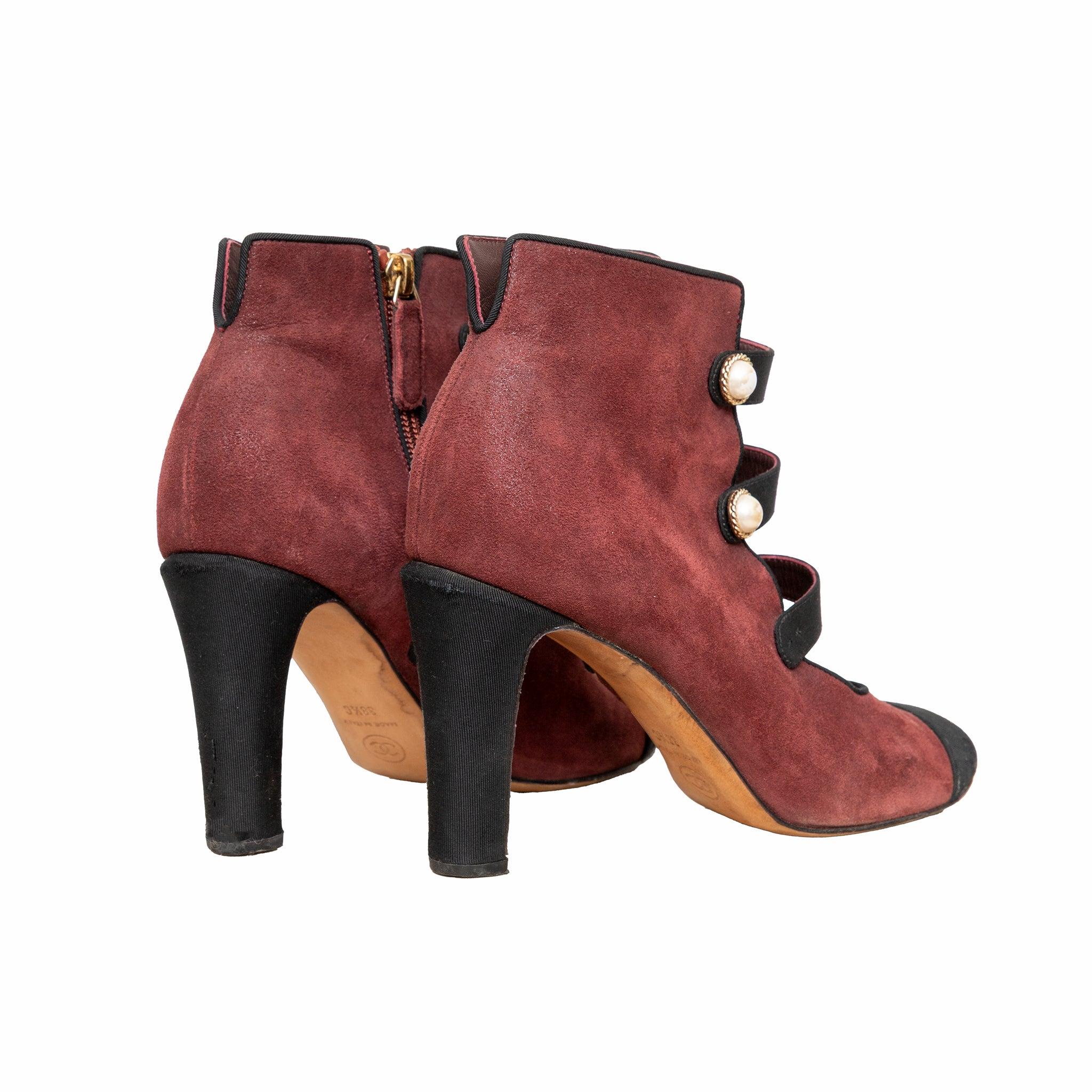 Chanel by Karl Lagerfeld, un par de botines de ante granate con botón de perla adornando las tiras delanteras, cierre de cremallera lateral, detalle de puntera y tacón alto esculpido de tejido negro. 
 Observaciones: faltan cuatro adornos de perlas.