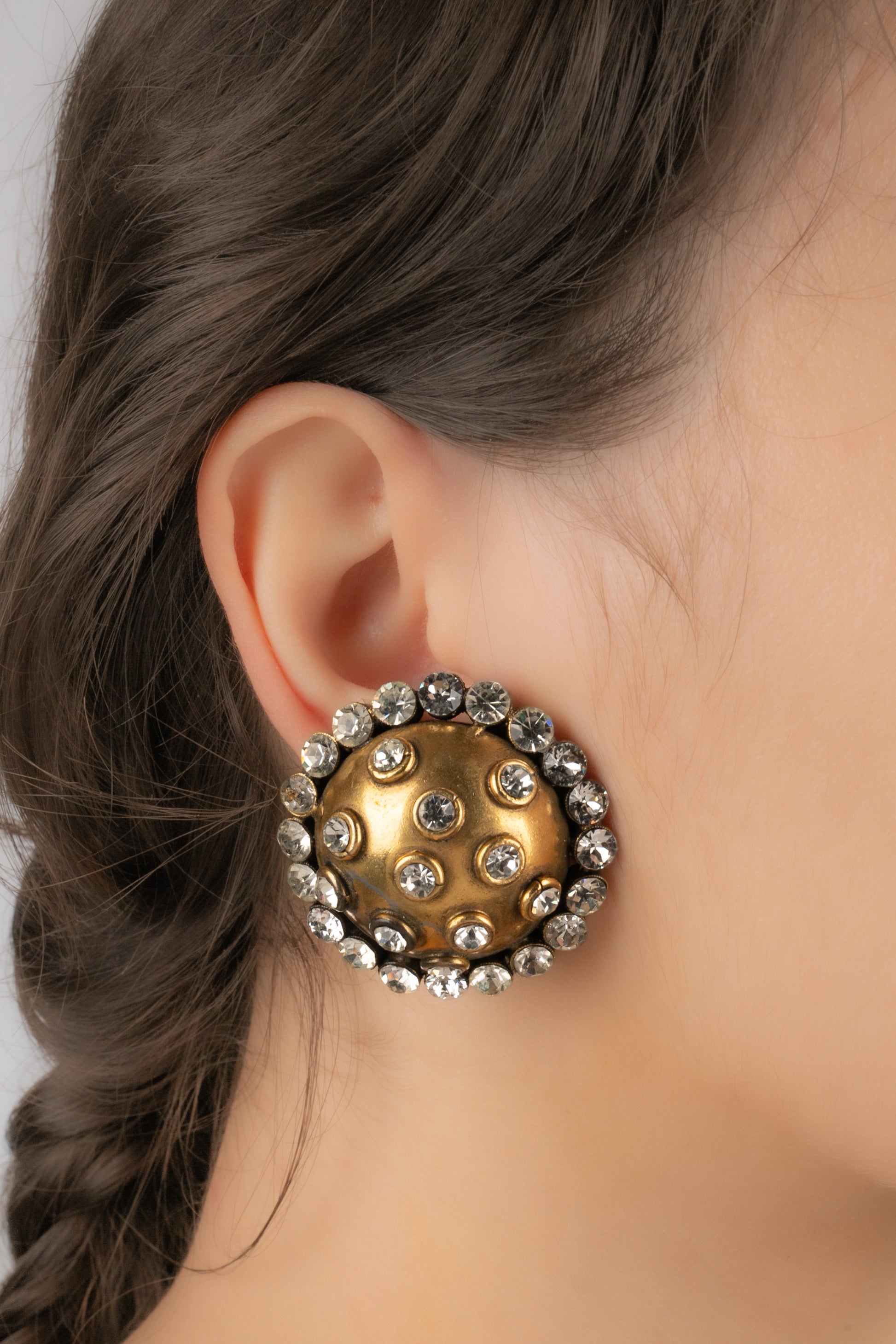 CHANEL - (Made in France) Antique-golden metal clip-on earrings ornamented with rhinestones.

Additional information:
Condition: Good condition
Dimensions: Diameter: 4 cm

Seller Reference: BOB239
