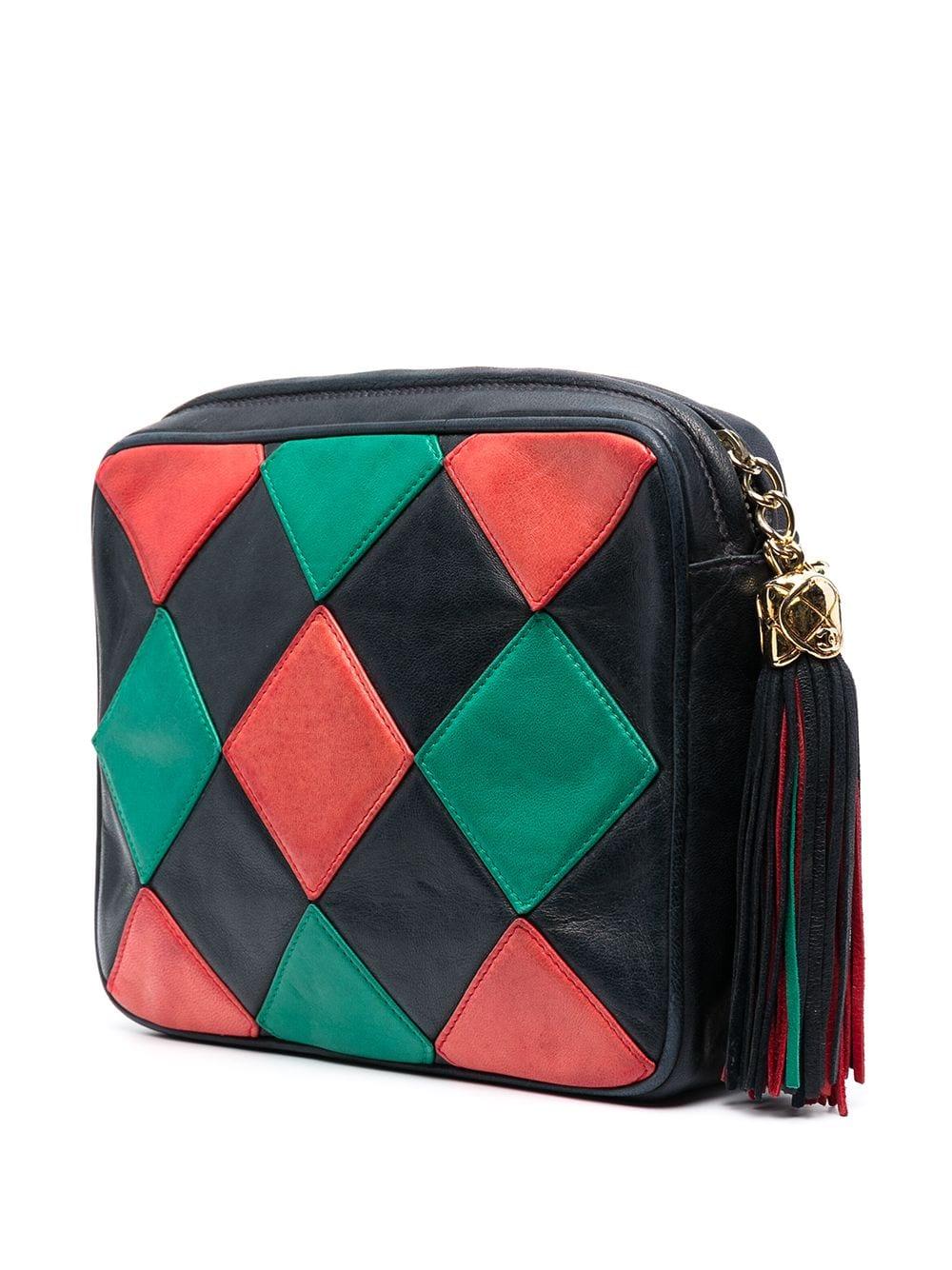 Beautiful vintage Limited Edition camera bag from Chanel. Featuring a retro red and green diamond patchwork design, with a matching large tassel featuring the iconic interlocking CC logo in gold-tone metal accents. The large compartment opens up to