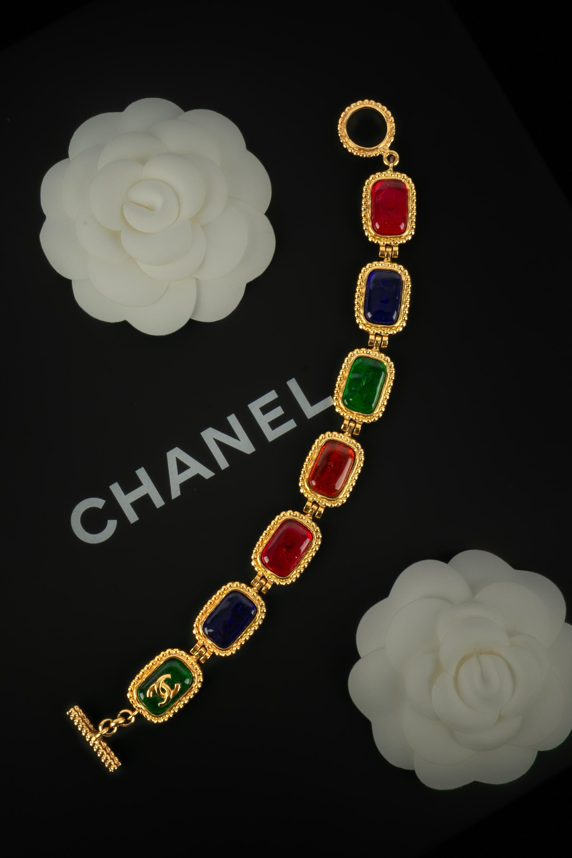 CHANEL - (Made in France) Golden metal articulated bracelet ornamented with multicolored glass paste cabochons. 1996 Fall-Winter Collection under the artistic direction of Karl Lagerfeld.

Condition:
Very good condition

Dimensions:
Length: 21 cm -