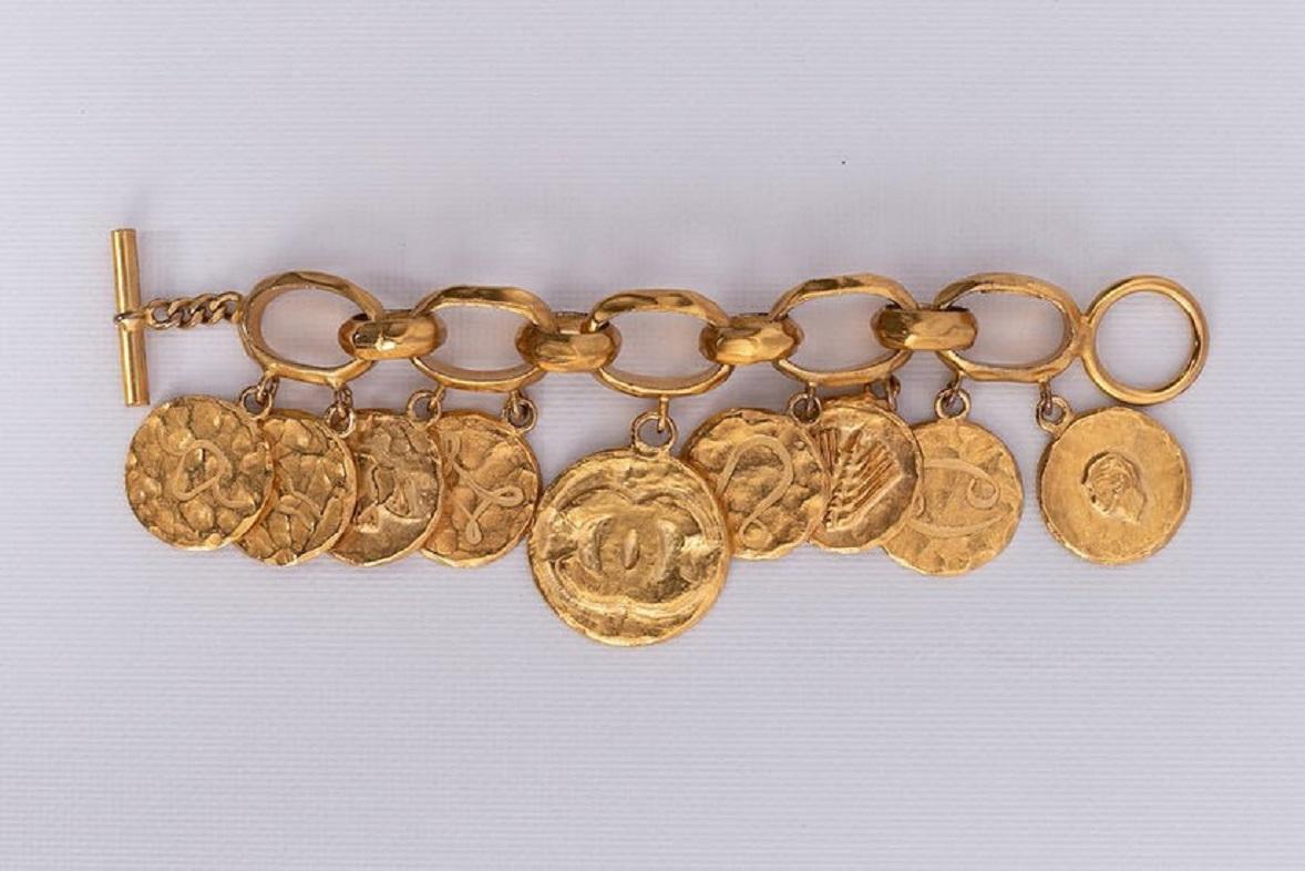 Chanel - (Made in France) Großes Armband aus vergoldetem Metall, verziert mit Medaillen, die mit astrologischen Zeichen und anderen Motiven geprägt sind. Frühjahrskollektion 1994.

Zusätzliche Informationen:
Abmessungen: Länge: 21 cm (8.26
