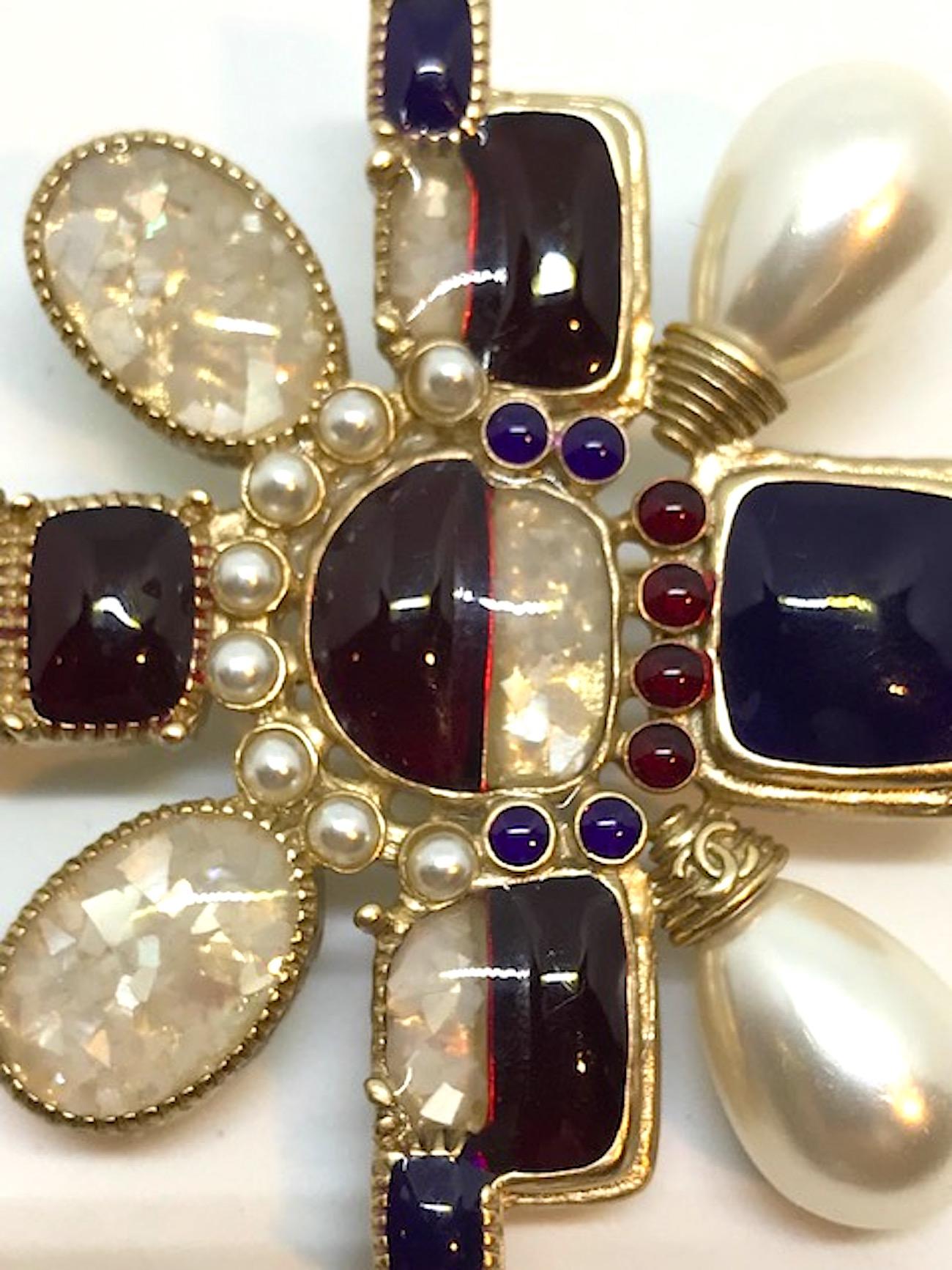 From the Chanel 2016 vacation collection is this twist on the traditional Maltese cross medallion pin. Satin gold plate and set with faux pearls, burgundy poured resin and Mother of Pearl confetti resin cabochons. Small double CC logo on the bottom