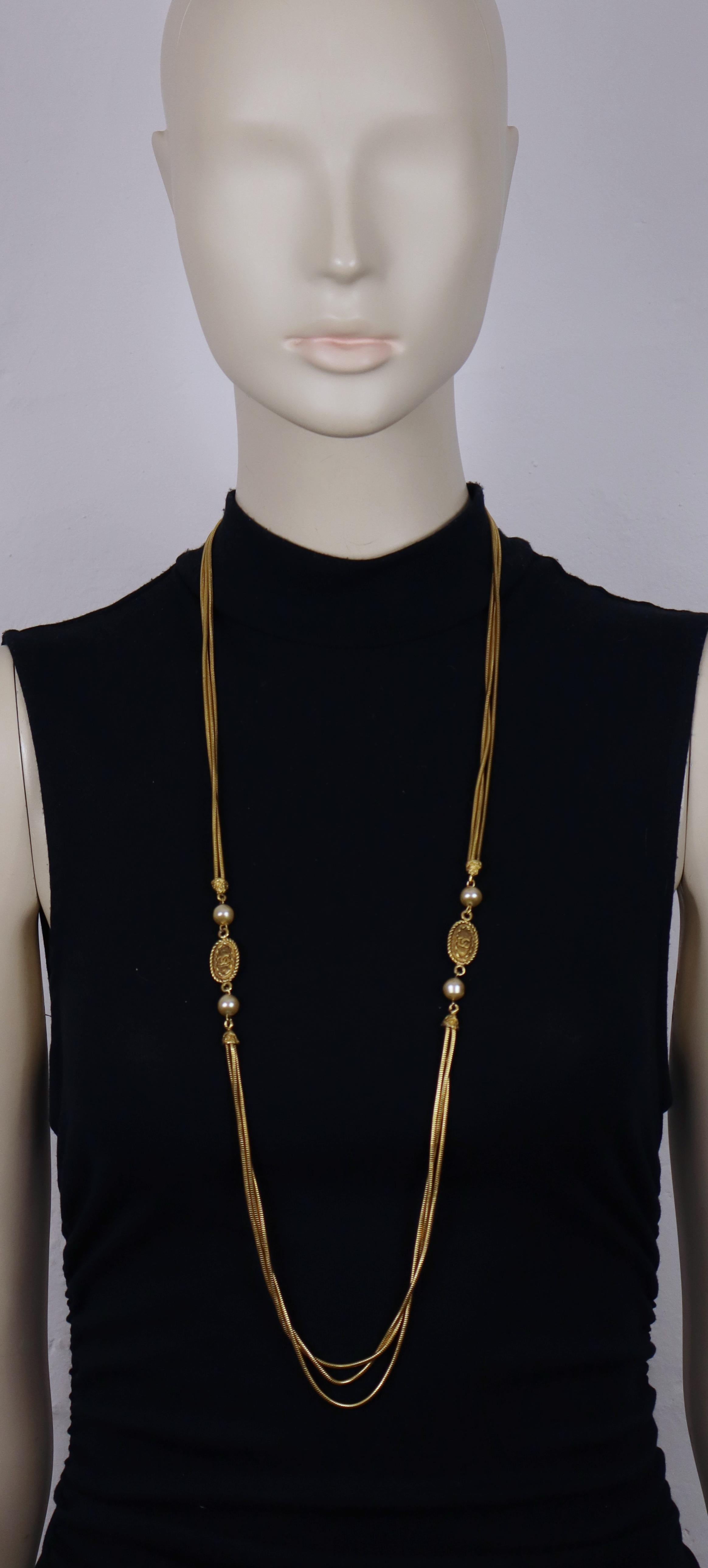 Attribuita a Chanel collana d'epoca con tripla catena a serpente in tonalità oro con due medaglioni ovali CC e perle finte.

Chiusura con bottone rotondo con logo CC.

Manca la targhetta ovale della firma Chanel (probabilmente persa).

Misure