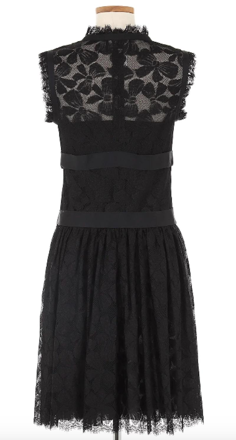 Chanel Autumn '05 Black Lace Short Dress With Bows at Front. This exquisite piece features intricate black lace with charming bows at the front, creating an alluring contrast of elegance and youthful charm.

Shoulders 16 in
Bust 31 in
Waist 31