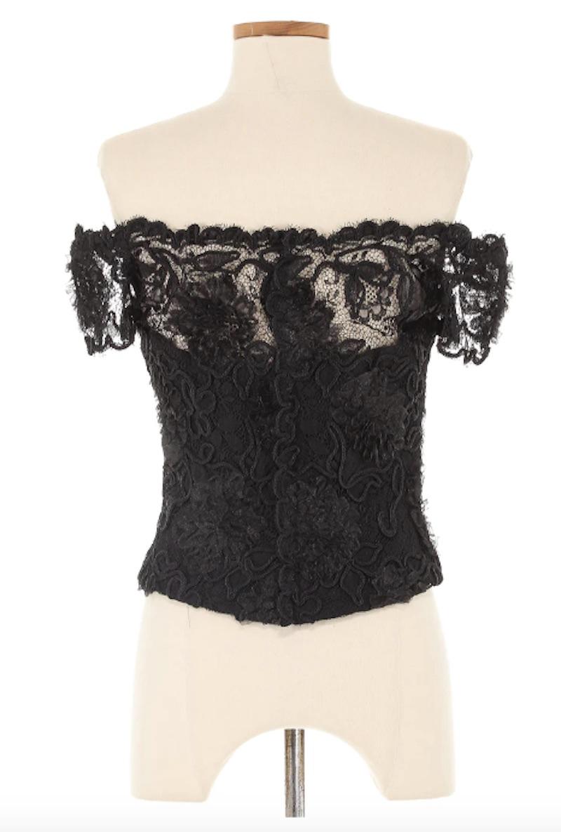 Chanel Autumn 1995 Black Lace Short Sleeve Blouse. Its delicate black lace fabric and short sleeves make it a versatile addition to any wardrobe, perfect for both formal occasions and everyday chic.

Shoulders 20 in
Bust 31 in
Waist 28 in
Sleeve 5