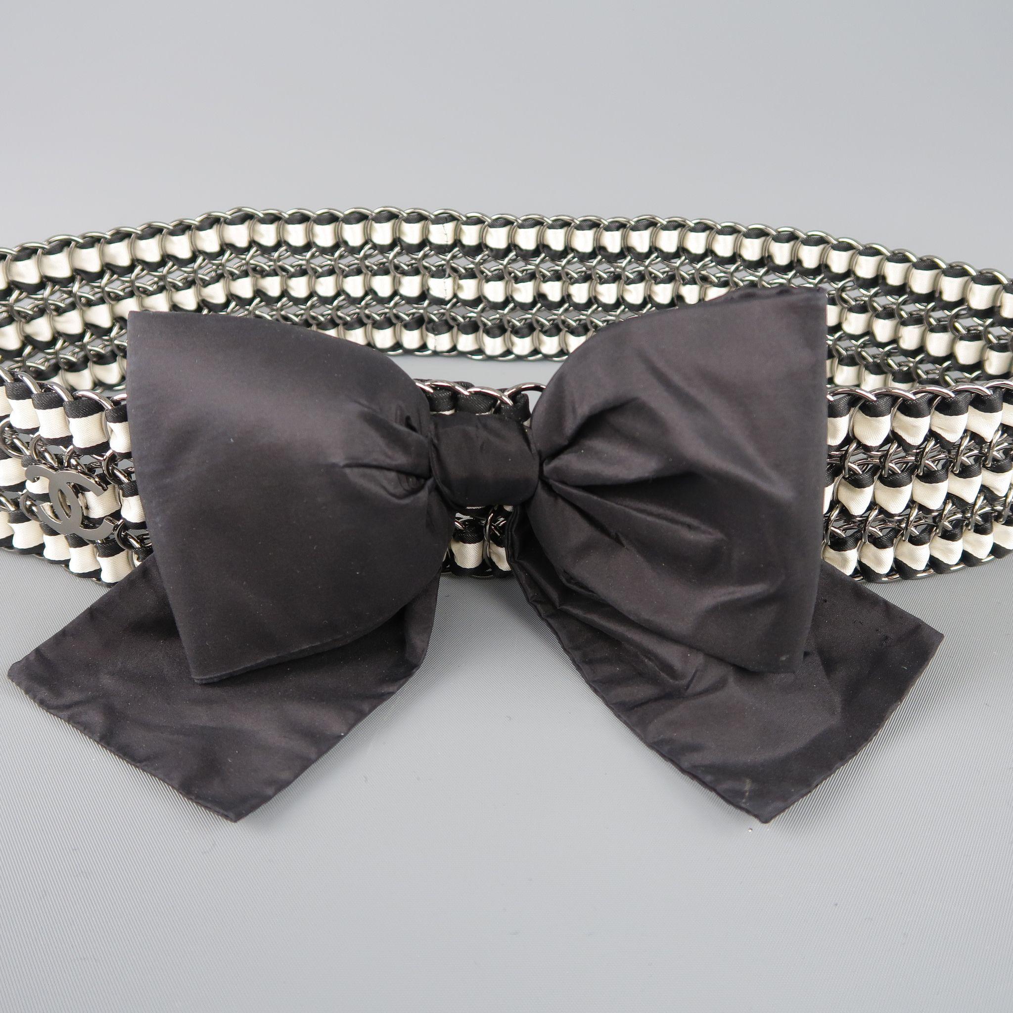 Classic CHANEL Fall Winter 2006 Collection statement  belt features a large, structured taffeta bow on a silver tone loop chainmail band with three black and cream silk ribbons woven through with CC emblem and charms on closure. Minor wear. Made in