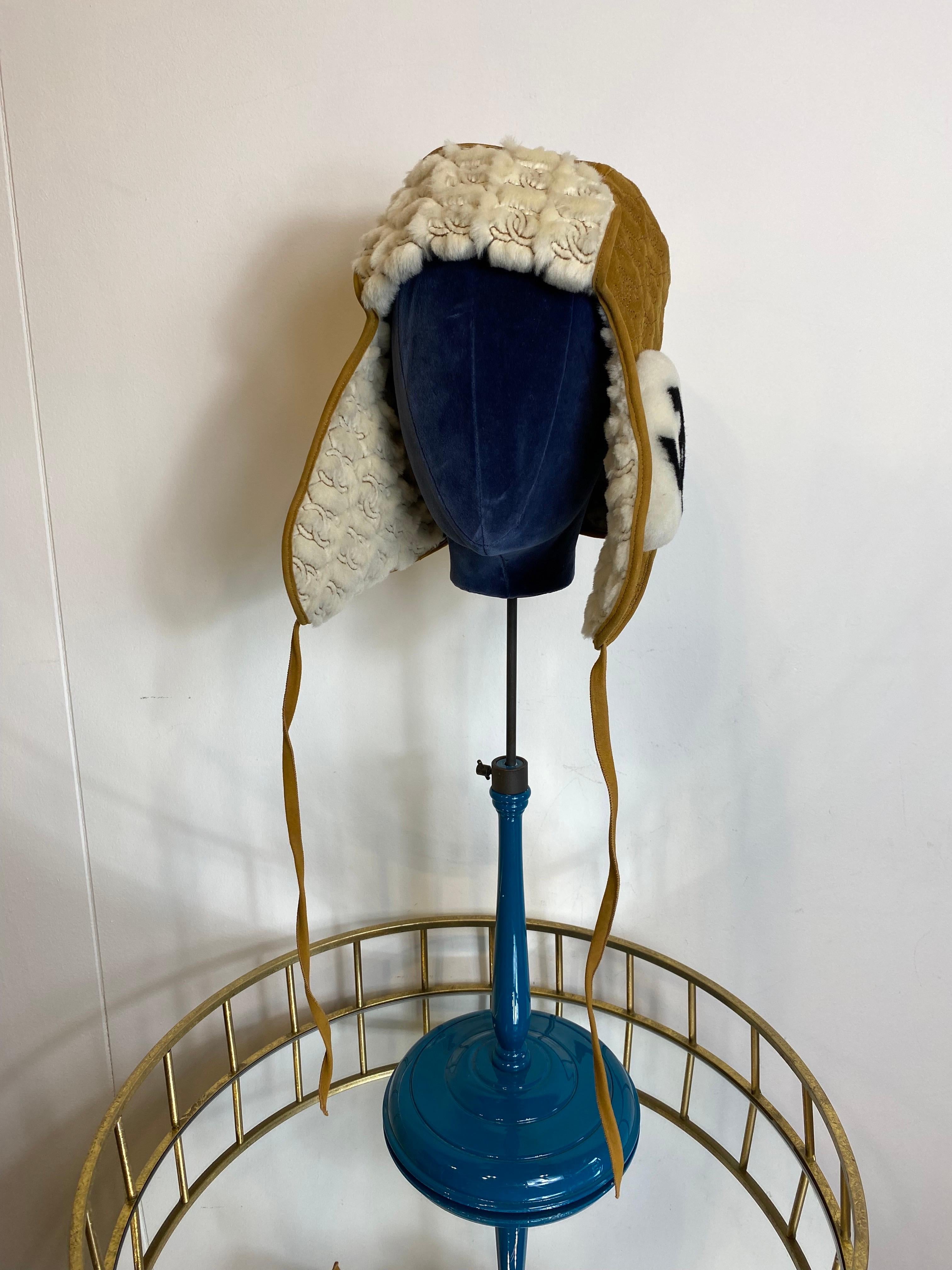 Chahel aviator hat in lambskin and lamb sharling, although the composition label is missing.
Camel color outside and white inside.
With a strap and logoed fur on the ears.

One size fits all.

Circumference 58 cm