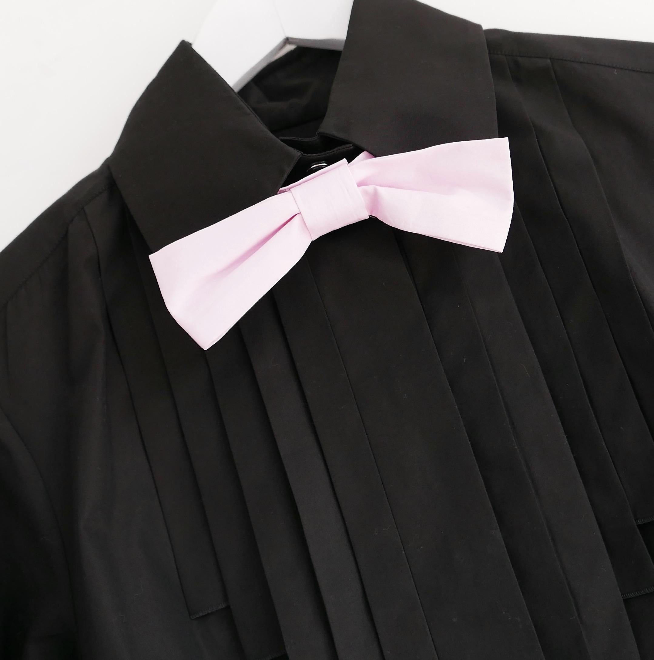 Absolutely stunning vintage Chanel blouse from the Fall 2007 Collection. Worn once and has been newly dry cleaned. Made from crisp black cotton with removable candy pink bow tie, it has sharply stitched Art Deco inspired panelling, black resin