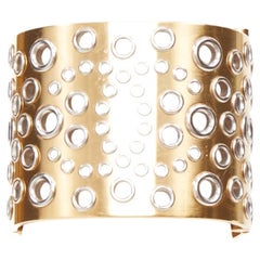Bracelet rigide Chanel B16 doré, avec logo CC argenté et œillets perforés