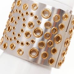 Bracelet rigide Chanel B16 argenté, or, avec logo CC et œillets perforés