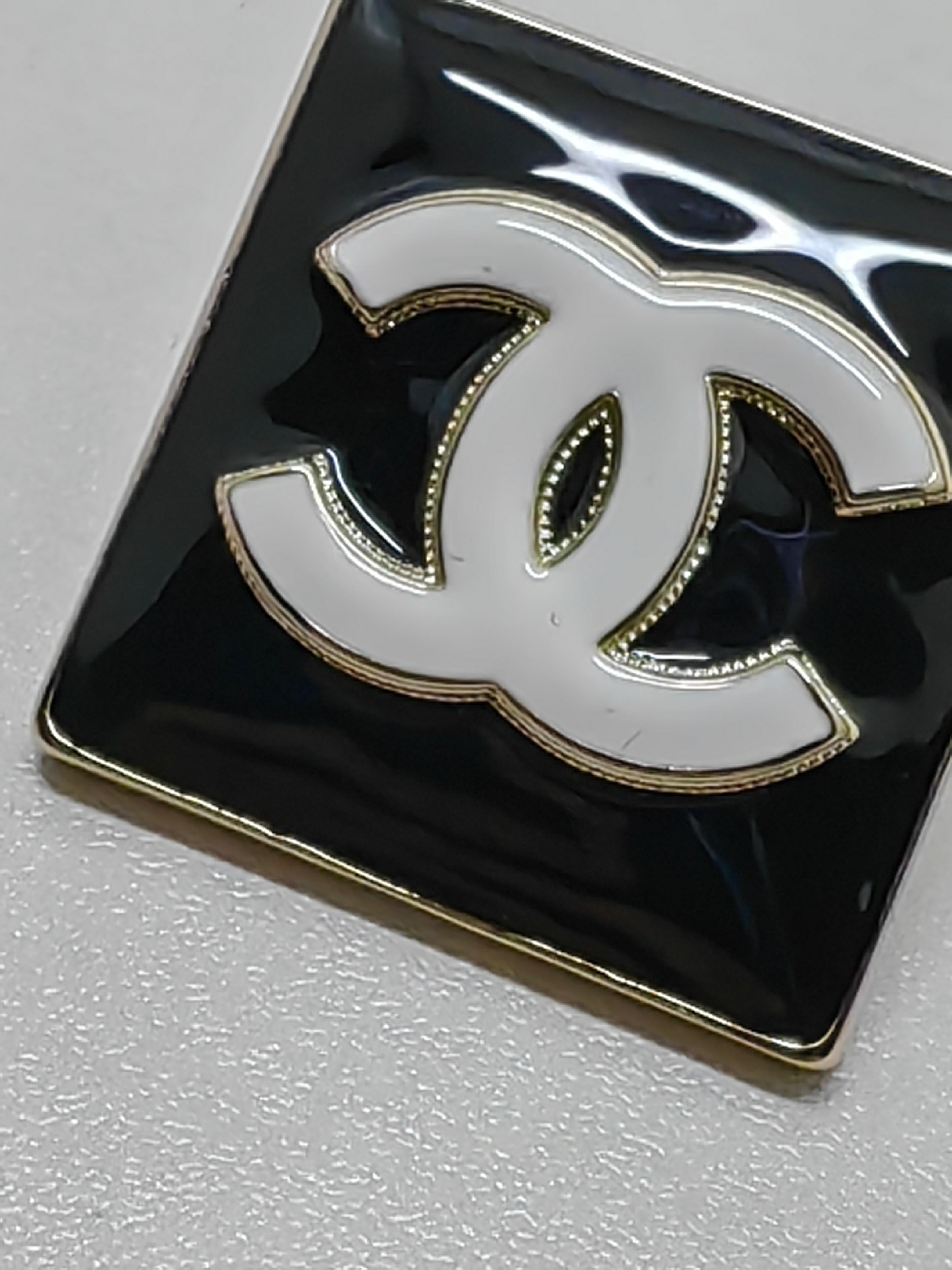 Elevate your look with the Chanel B22 Large Square Black Enamel Stud CC Earrings, a timeless blend of luxury and sophistication. These elegant earrings feature:

Iconic Design: A bold, large square silhouette with a glossy black enamel finish.
CC