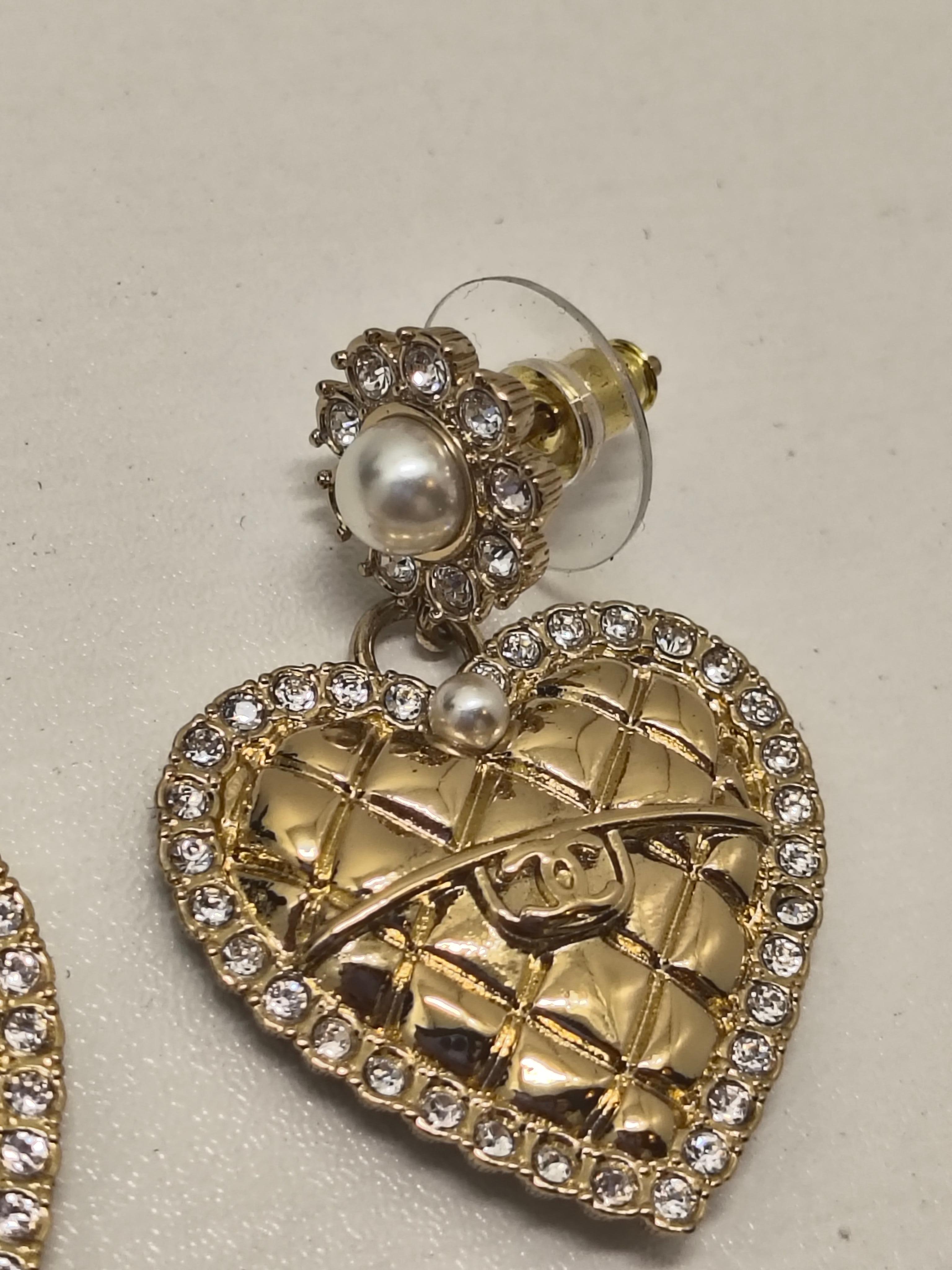 Dalla romantica Collection'S B24 di Chanel, questi orecchini di grande effetto riprendono il caratteristico design trapuntato della maison con un tocco giocoso e femminile. A forma di cuore trapuntato in tonalità oro, ogni pezzo è incorniciato da