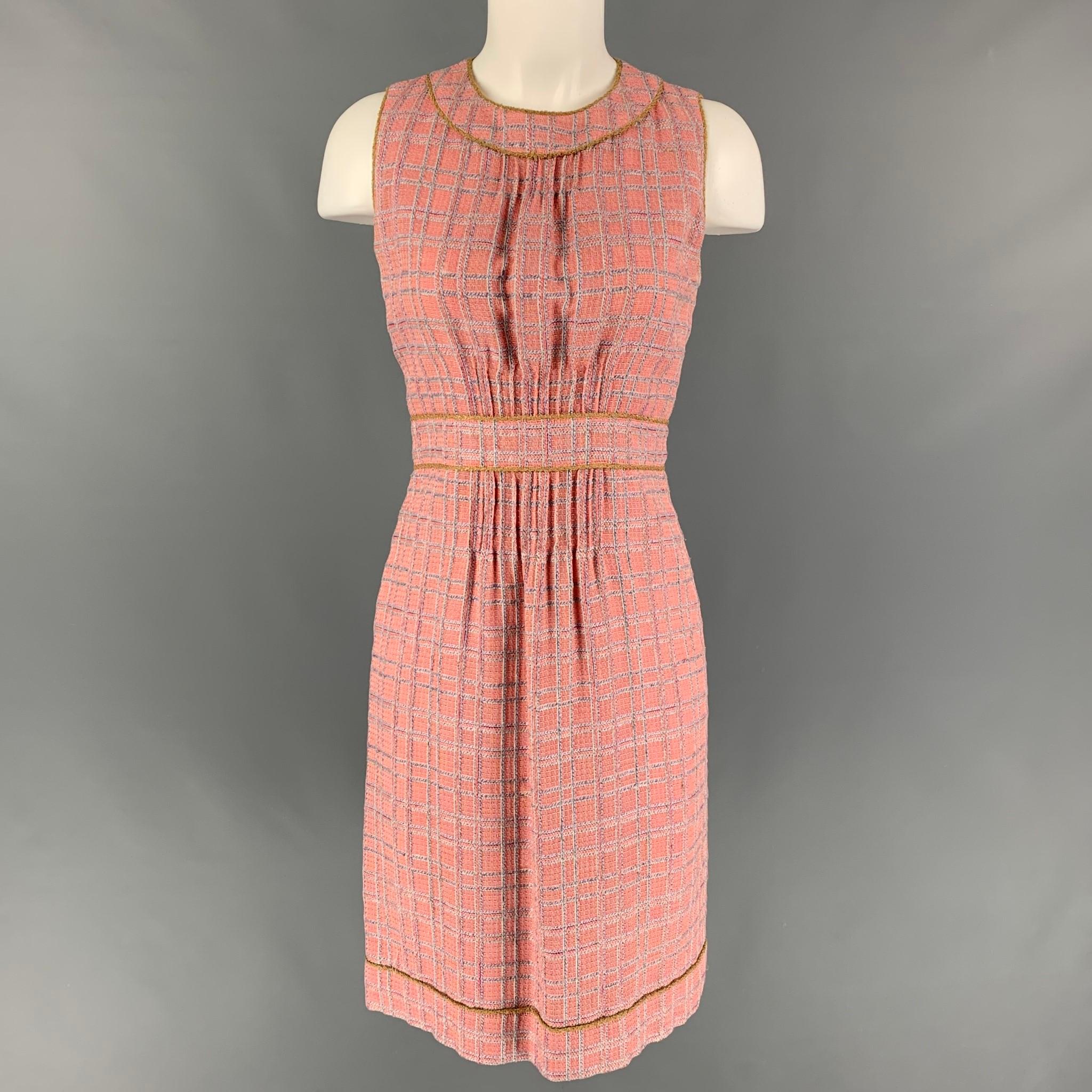 CHANEL dress set comes in a pink & off white boucle cotton blend featuring a shift style, sleeveless, and back zip up closure. Includes a belted coat with two camellia pins. Made in France. 

Very Good Pre-Owned Condition.
Marked: B2483 04P /