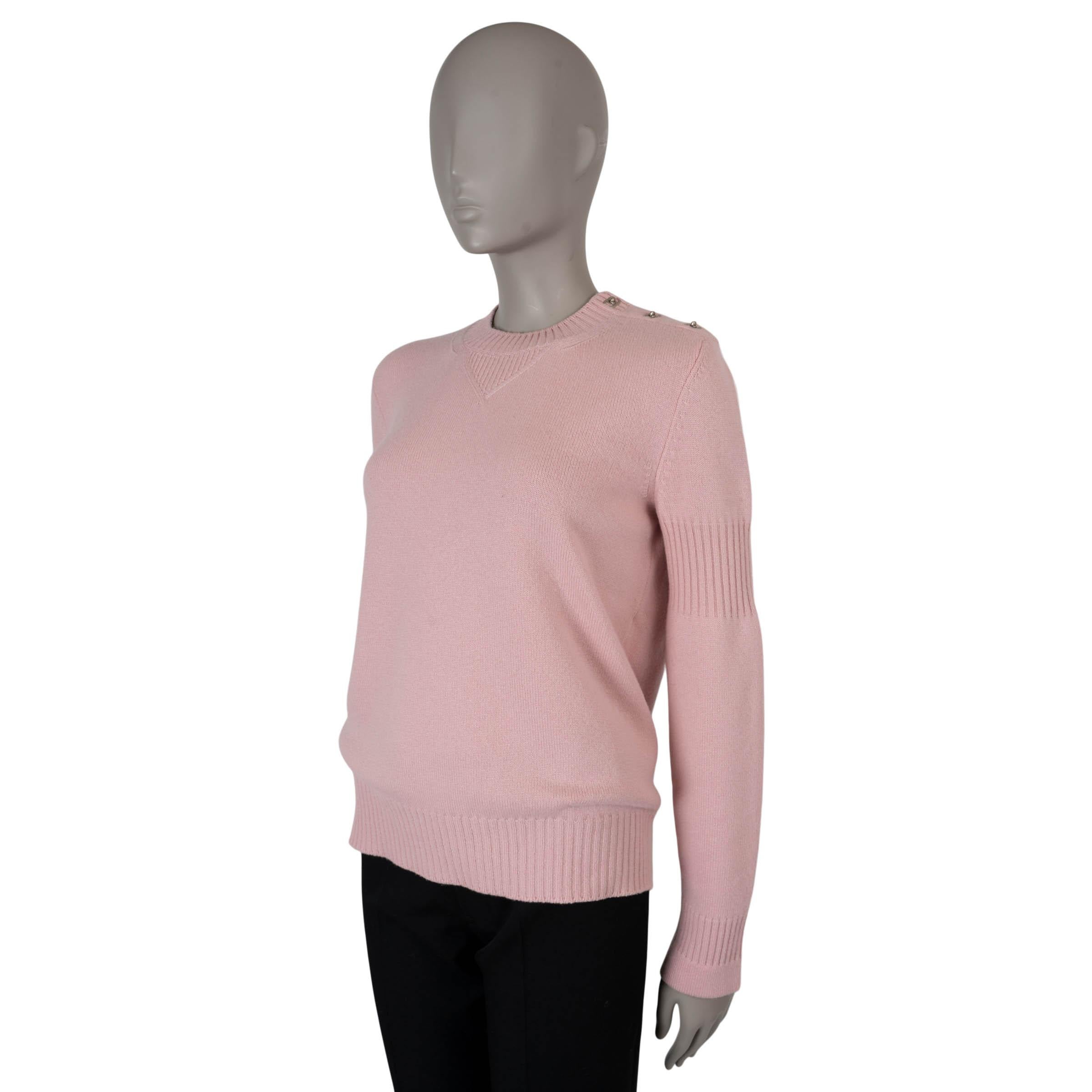 Dieser klassische Pullover von Chanel ist zu 100 % authentisch und wurde aus weichem, rosafarbenem Kaschmir (100 %) gefertigt. Es hat elegante silberfarbene CC-Drehverschlüsse am Hals, einen Rundhalsausschnitt, Rippstrickbündchen und raffinierte