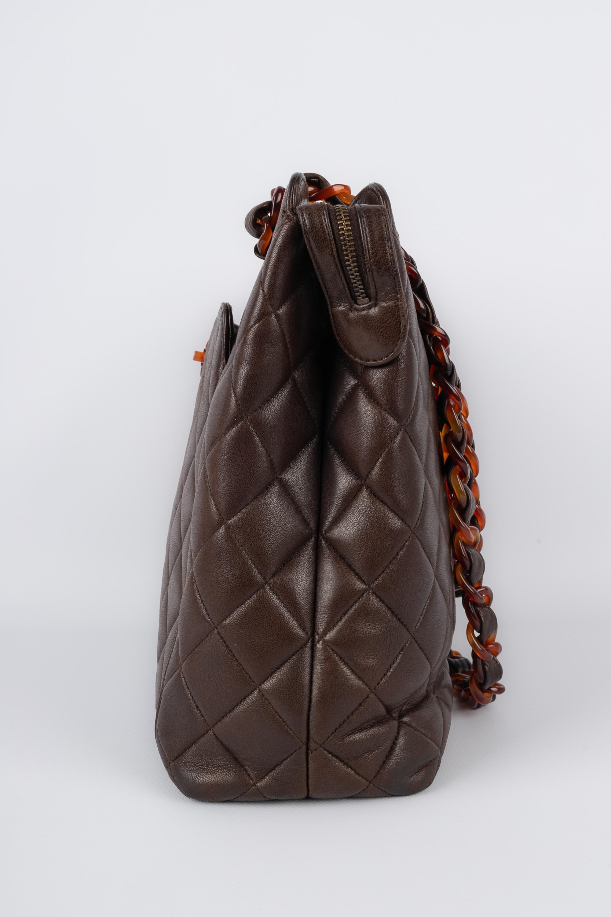 CHANEL - (Made in France) Quilted brown leather bag with tortoiseshell bakelite elements. 1994 circa Collection.

Condition:
Good condition

Dimensions:
Length: 30 cm - Height: 27 cm - Depth: 8.5 cm - Handle length: 62 cm

S17
