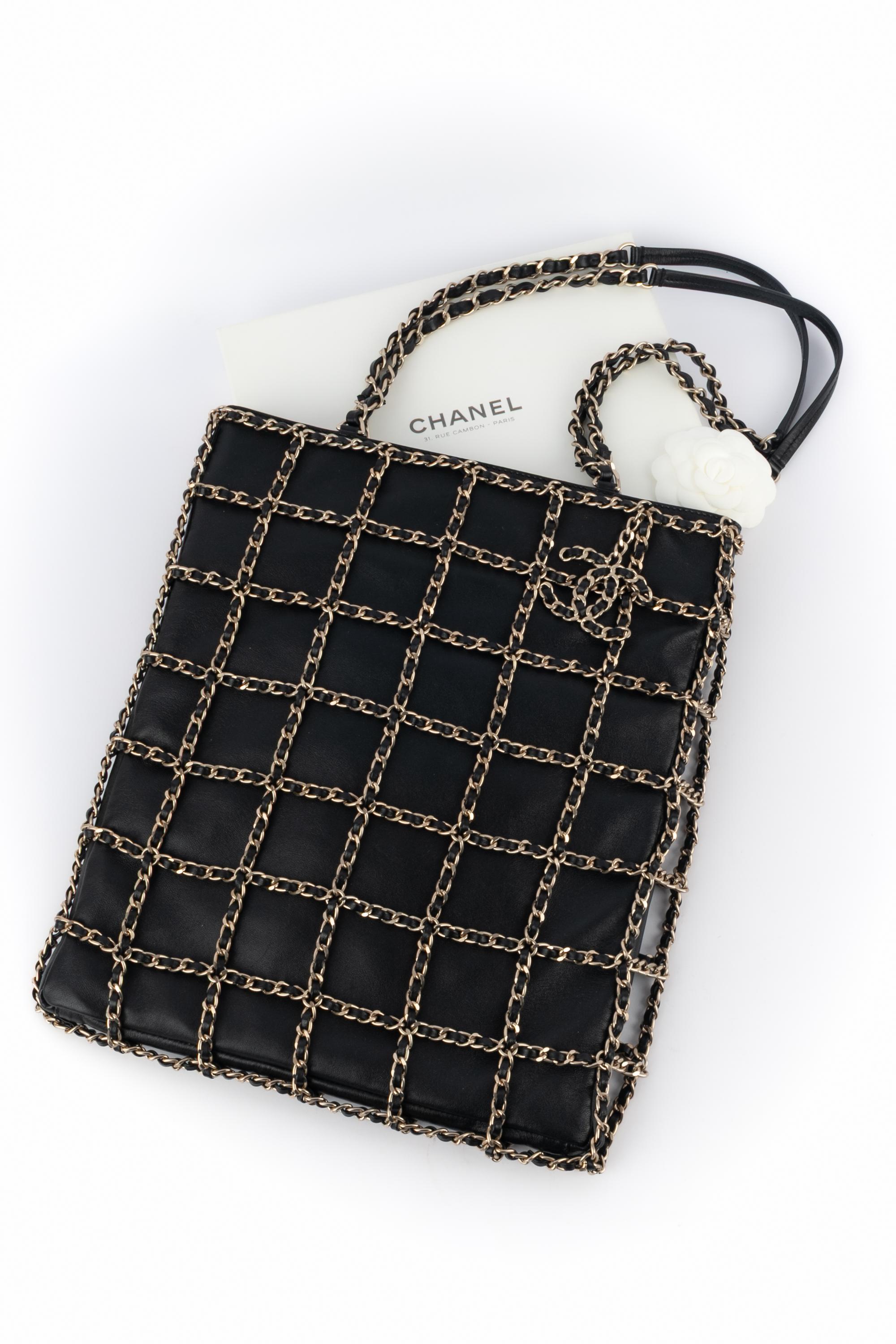 CHANEL - (Fabriqué en Italie) Sac en cuir d'agneau noir superposé de chaînes en métal doré entrelacées de cuir noir. Collection Cruise 2019.

Condit :
Très bon état.

Dimensions :
Longueur : 29 cm - Hauteur : 34 cm - Profondeur : 2 cm - Poignée : 70