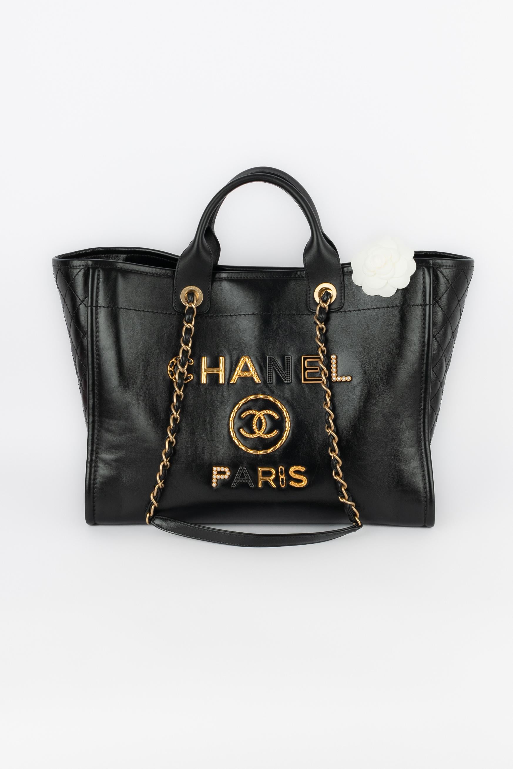 CHANEL - (Made in Italy) Antiqued black calfskin 'Deauville' bag partially quilted and decorated with the house name writing, costume pearly cabochons, and rhinestones. Piece with a serial number. A 2020 Collection.

Condition:
Very good