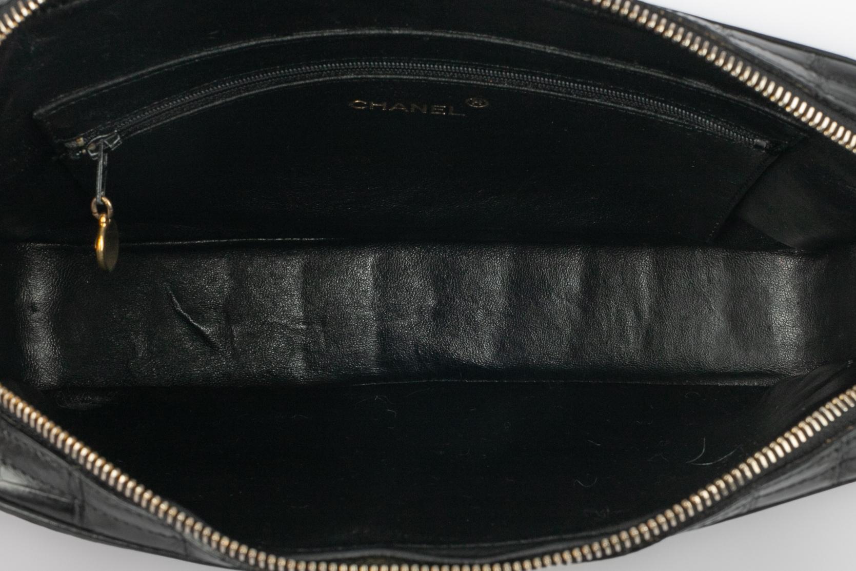 CHANEL - (Made in France) Black crocodile 'camera' bag. Zipper and golden metal double handle interlaced with lamb leather. External pockets.

Condition:
Good condition

Dimensions:
Length: 28 cm - Height: 19 cm - Depth: 6 cm - Handle length: 105