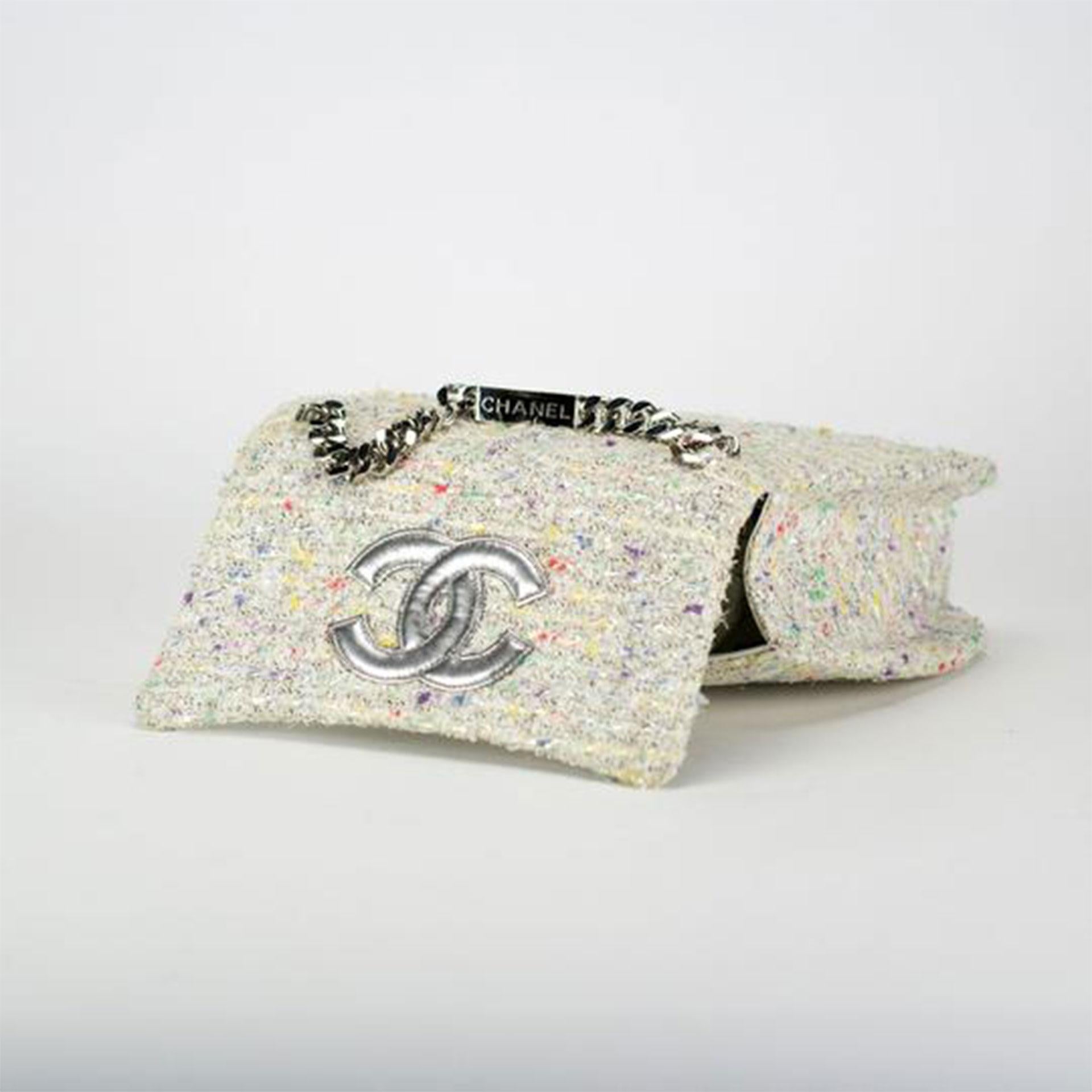 Chanel confetti tweed flap with large CC logo and name plate chain

1996 {VINTAGE 26 Years}
Silver hardware
Interior center zipper pocket
Additional center pocket
Interior white lambskin lining
Magnetic closure
10