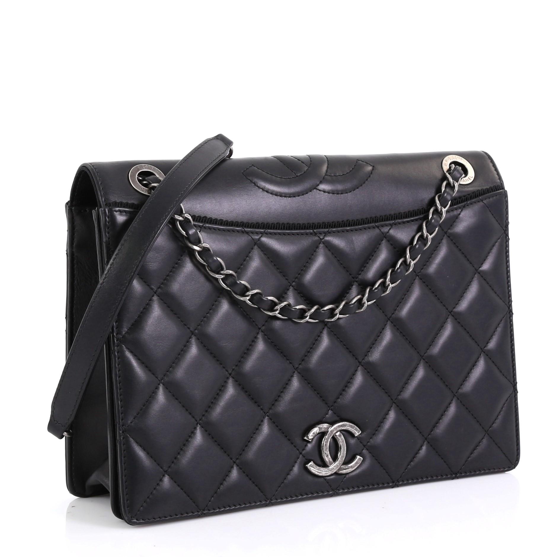 This Chanel Ballerine Flap Bag Quilted Lambskin Medium, crafted from black quilted lambskin leather, features woven-in leather chain strap with leather pad, CC logo at front flap, and ruthenium-tone hardware. Its magnetic snap closure opens to a red
