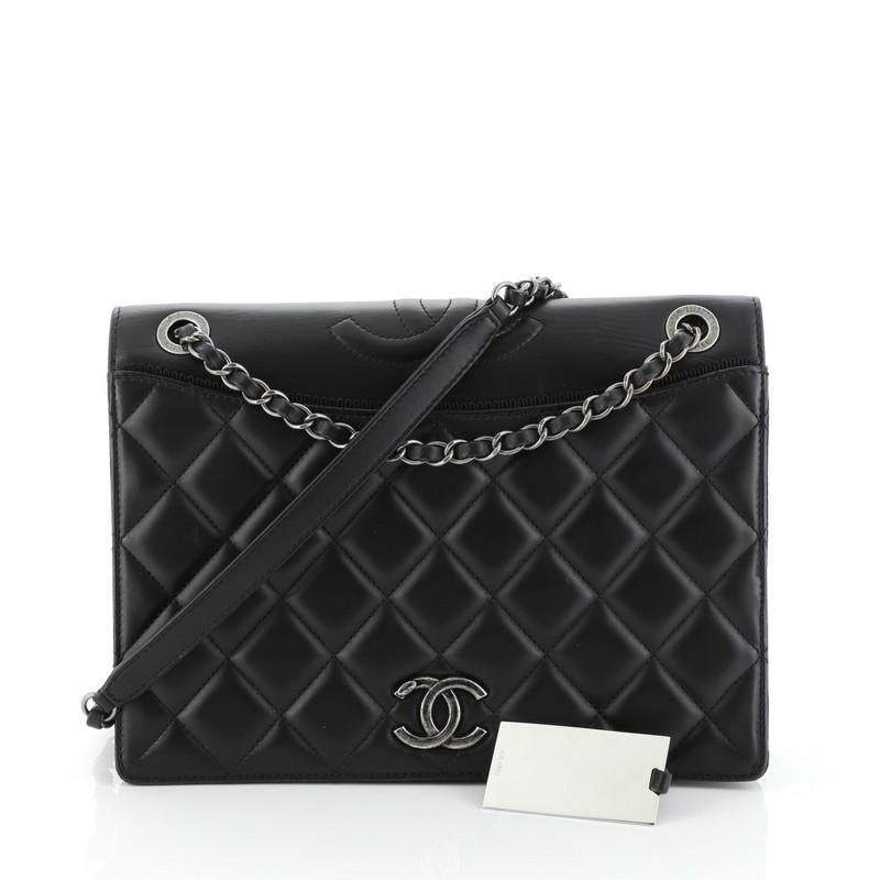 This Chanel Ballerine Flap Bag Quilted Lambskin Medium, crafted from black quilted lambskin leather, features woven-in leather chain strap with leather pad, CC logo at front flap, and aged silver-tone hardware. Its magnetic snap closure opens to a