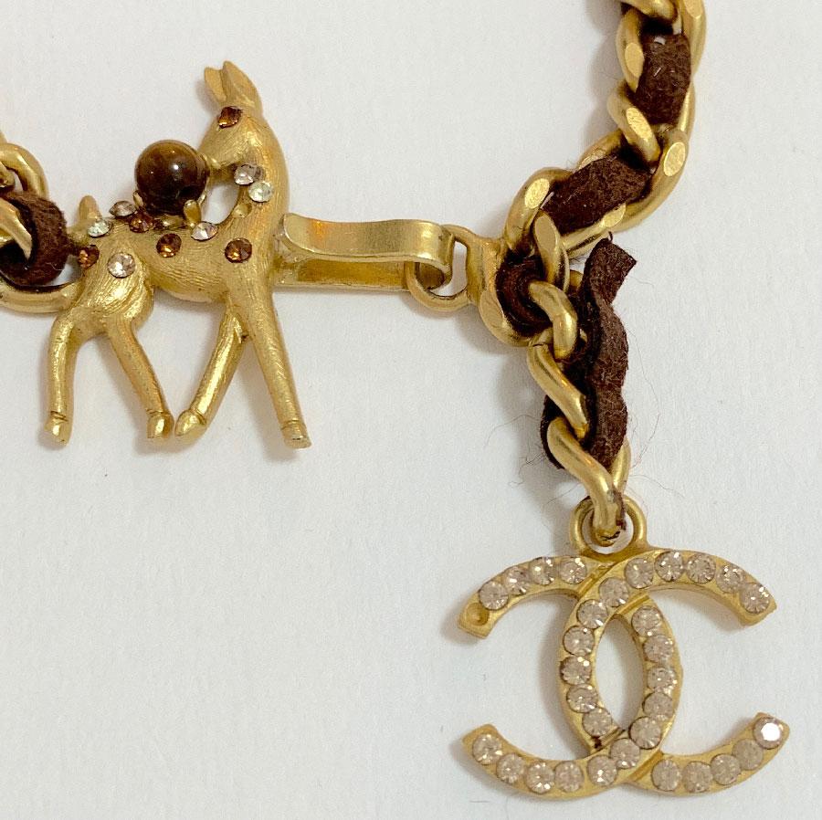 Nice CHANEL bracelet. It is a  matte golden metal chain interlaced with brown leather. the hook clasp represents a fawn (Bambi) set with rhinestones. The bracelet ends with a CC set with white rhinestones.
It is a jewel from the 2001