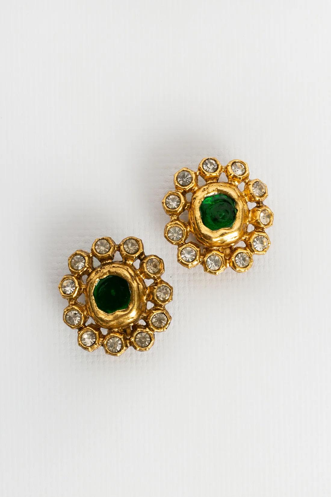 Chanel (Made in France) Clip-on round gilded metal earrings paved with rhinestones and decorated in the center with a green glass paste cabochon.

Additional information:

Dimensions: 
2.5 W x 2.8 H cm (0.98