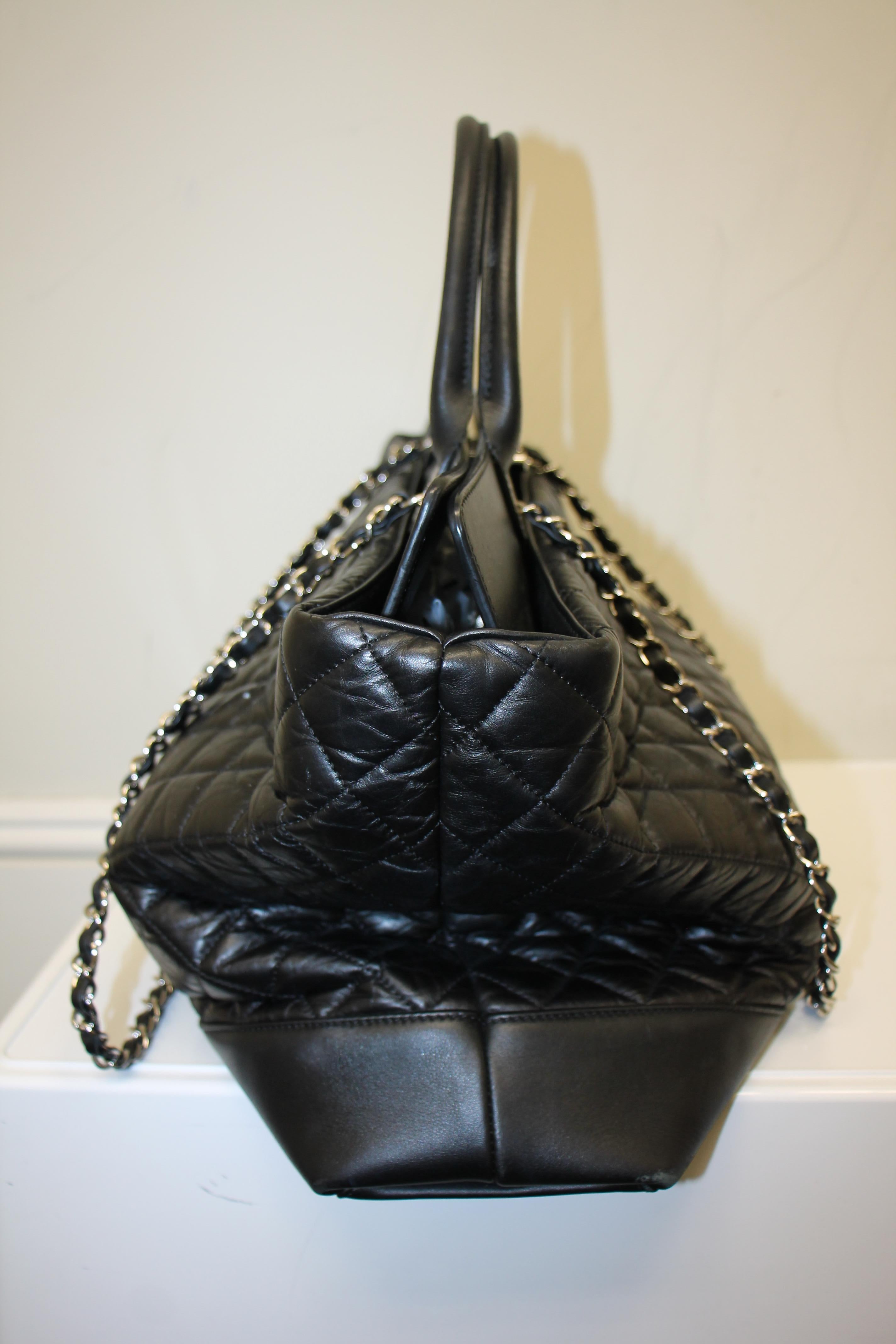 Black quilted calfskin leather. Silver-tone hardware. Turn-lock closure at top. Dual woven chain-link shoulder straps with leather shoulder guard. 
