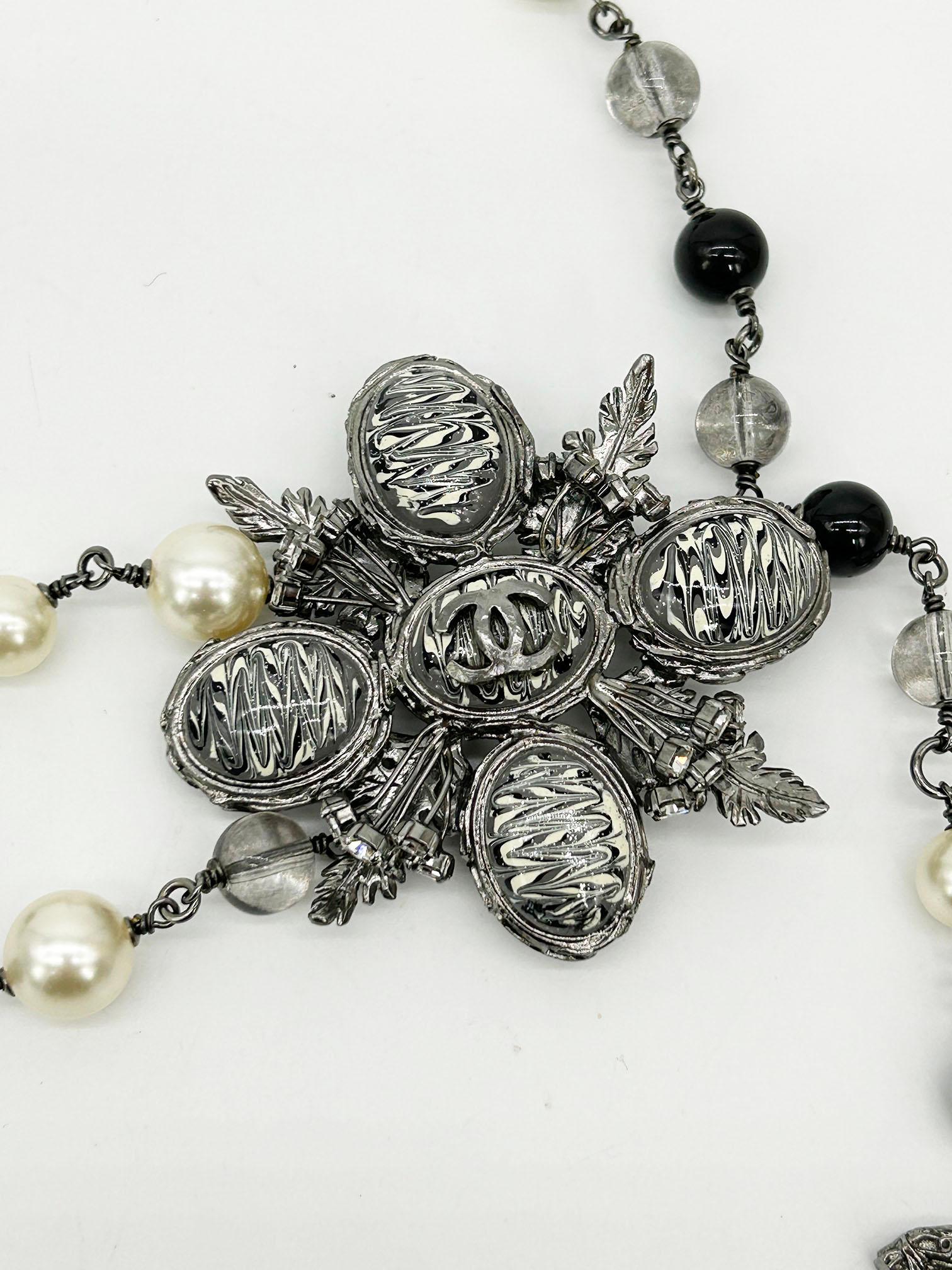 Chanel Beaded Marble Flower Belt Necklace in excellent condition. Black, gray, pearl and metal beads with gunmetal chain. gray, black and white glitter marble flower emblem with gunmetal hardware, rhinestones and CC logo in center. CC logo charm on