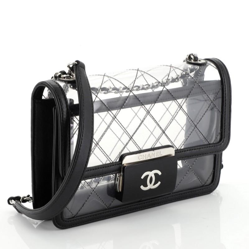 This Chanel Beauty Lock Flap Bag Quilted PVC With Lambskin Mini, crafted from clear quilted PVC with black lambskin leather, features woven-in leather chain strap with shoulder pad, plexiglass closure with CC logo, leather trim and silver-tone