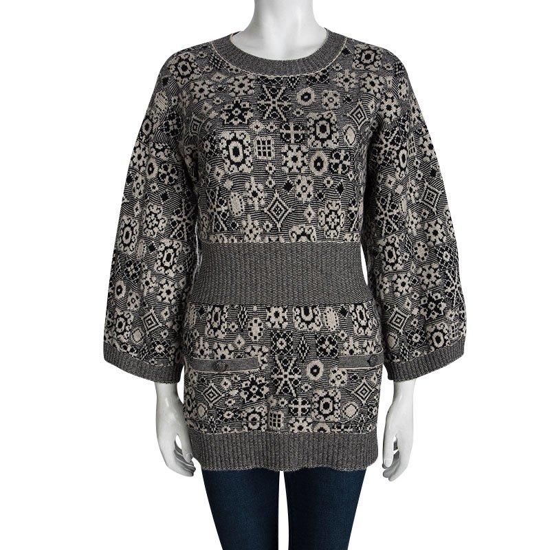 Plush and warm, this Sweater Tunic by Chanel is one creation that will brighten your chilly days. Luxuriously made from Cashmere, this piece is accentuated with bell sleeves, a round neck, and bands on the hem and waist. Button closures at the back