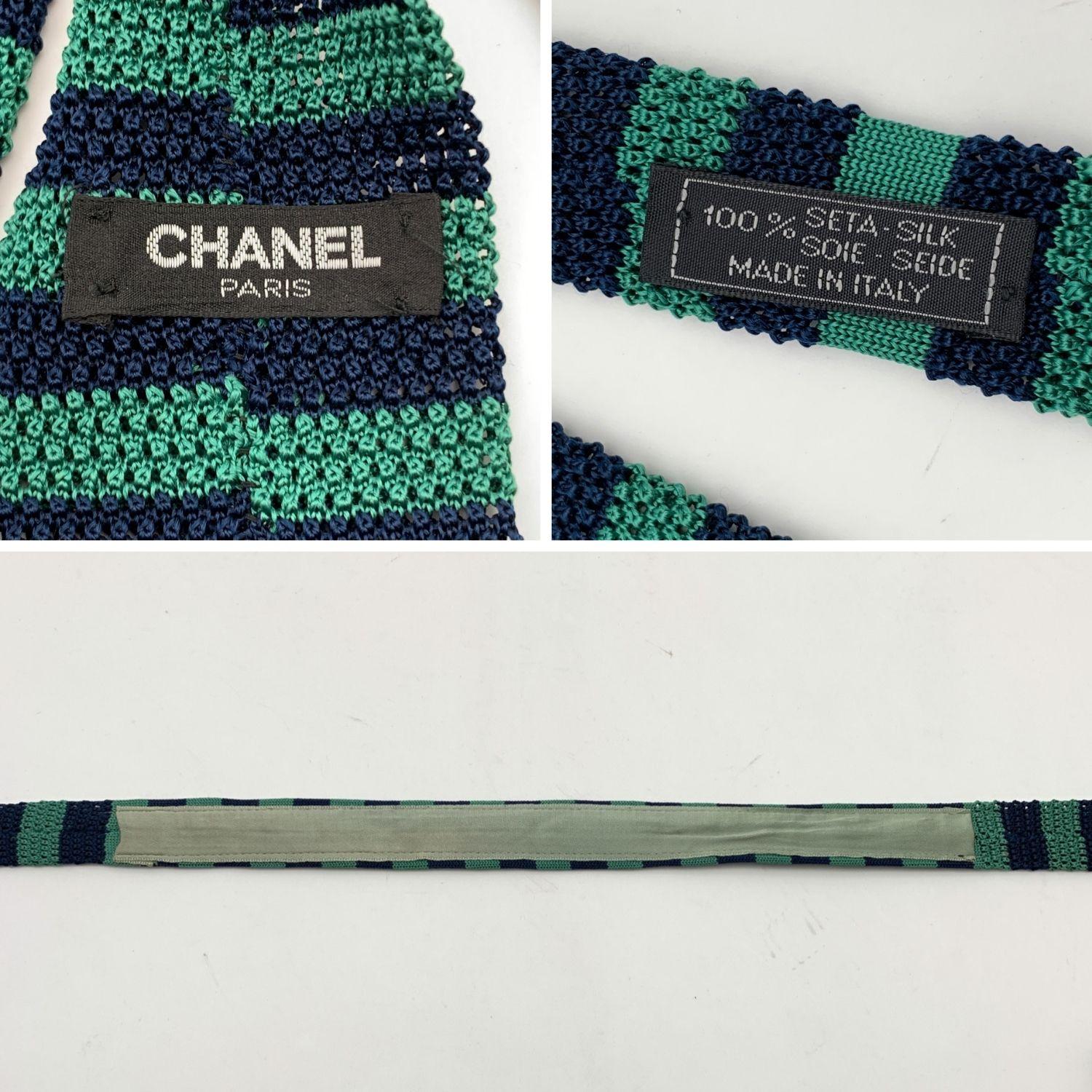 Elegant Chanel knitted neck tie in green and blue color. Striped design. Gold metal chain detail on the back along the hem. Embroidered CC Logo in yellow color. Scalloped hem. Composition: 100% Silk. Chanel composition tag attached. Made in Italy.