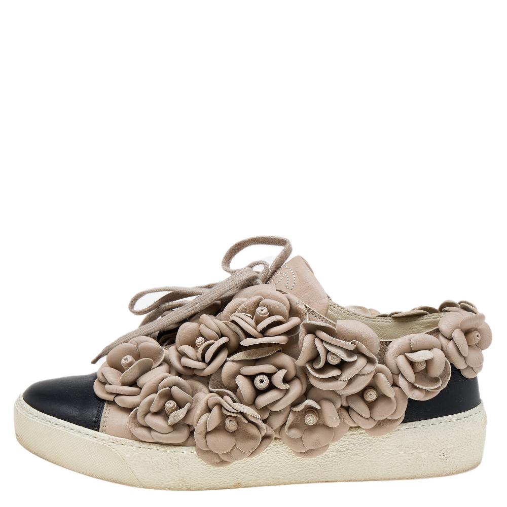 A classic low-top silhouette elevated by Chanel's signature Camellia motifs! The sneakers have been created using leather in beige and black shades. Style them with your casuals and make a statement.

Includes: Original Dustbag, Info booklet