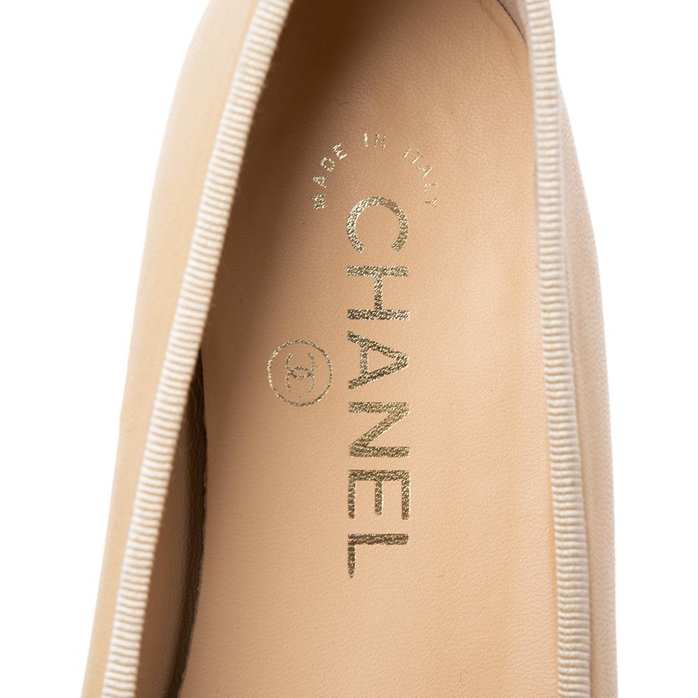 Dazzle in comfort with these ballet flats from Chanel. They've been created using beige leather and added with CC-detailed black cap toes and little bows. The flats are complete with leather insoles for your ease.

Includes: Original Box