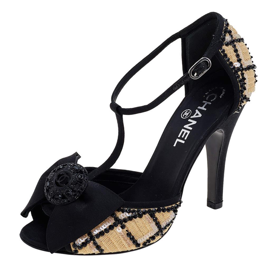 Keep it elegant and chic with these sandals from Chanel. Made from black-beige mesh and fabric on the exterior, they are adorned with sequin detailing, peep-toes, a crystal-embellished motif on the front, and an ankle strap. They are elevated on 11