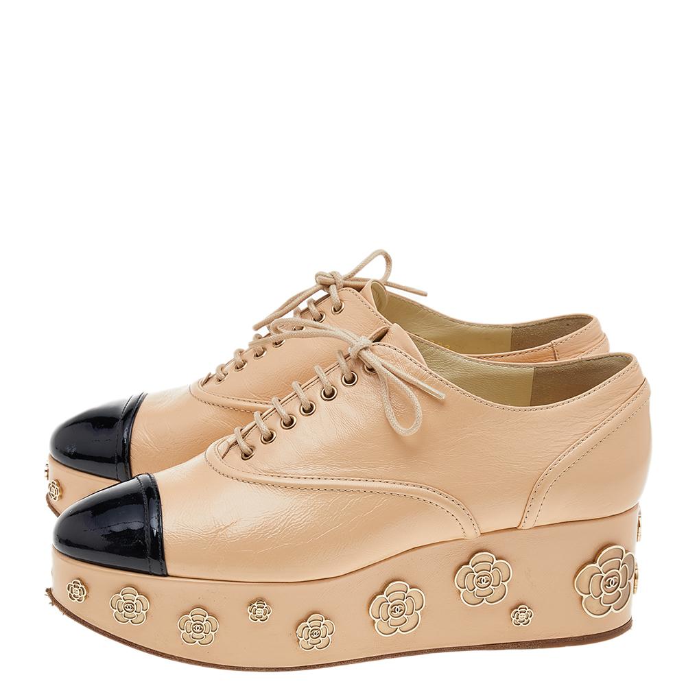From the House of Chanel, these sneakers will elevate the look of any attire in seconds. They are designed using beige-black patent leather and leather with the Camellia motifs accentuating the platforms. They show lace-ups on the vamps and
