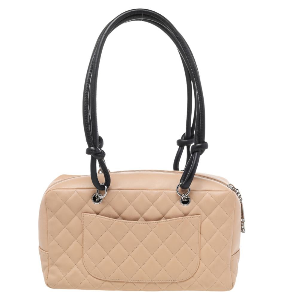 Radiate with elegance when you swing this Bowler bag from Chanel. Beautifully crafted from leather in beige, and designed with the CC logo on the side, this bag is a beauty. A zip closure secures a spacious interior and the bag is held by two