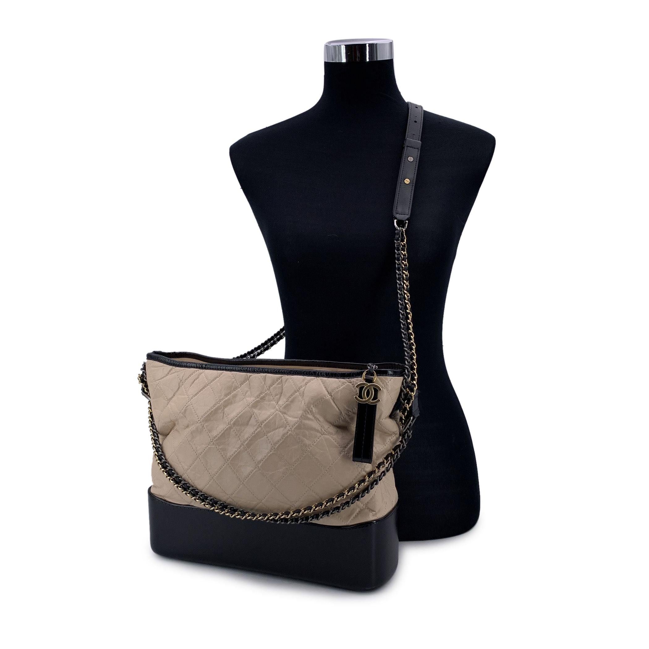Esta hermosa Bolsa se entregará con un certificado de autenticidad expedido por terceros autentificadores. El certificado se entregará sin coste alguno. Bolso Chanel Gabrielle Large elaborado en piel acolchada beige y piel negra. Periodo/Era: