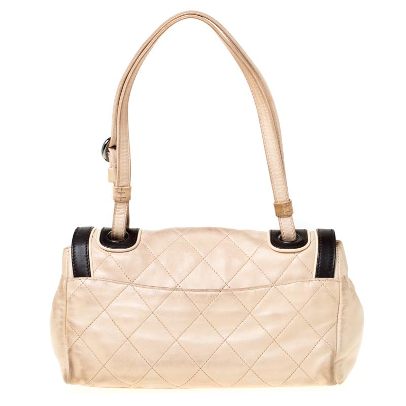 Charm your way through every gathering by swinging this Reissue shoulder bag from Chanel. Crafted from leather, the bag has a beige exterior that features black trimmings and the signature quilted pattern. It comes with a flap that has a turn-lock
