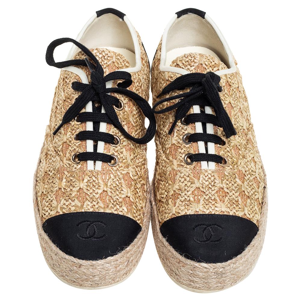 Step out in style with these chic espadrille sneakers from Chanel! These beige shoes feature a woven exterior with black round toes, CC logo, lace-ups, and durable rubber soles that offer a comfortable walk.

