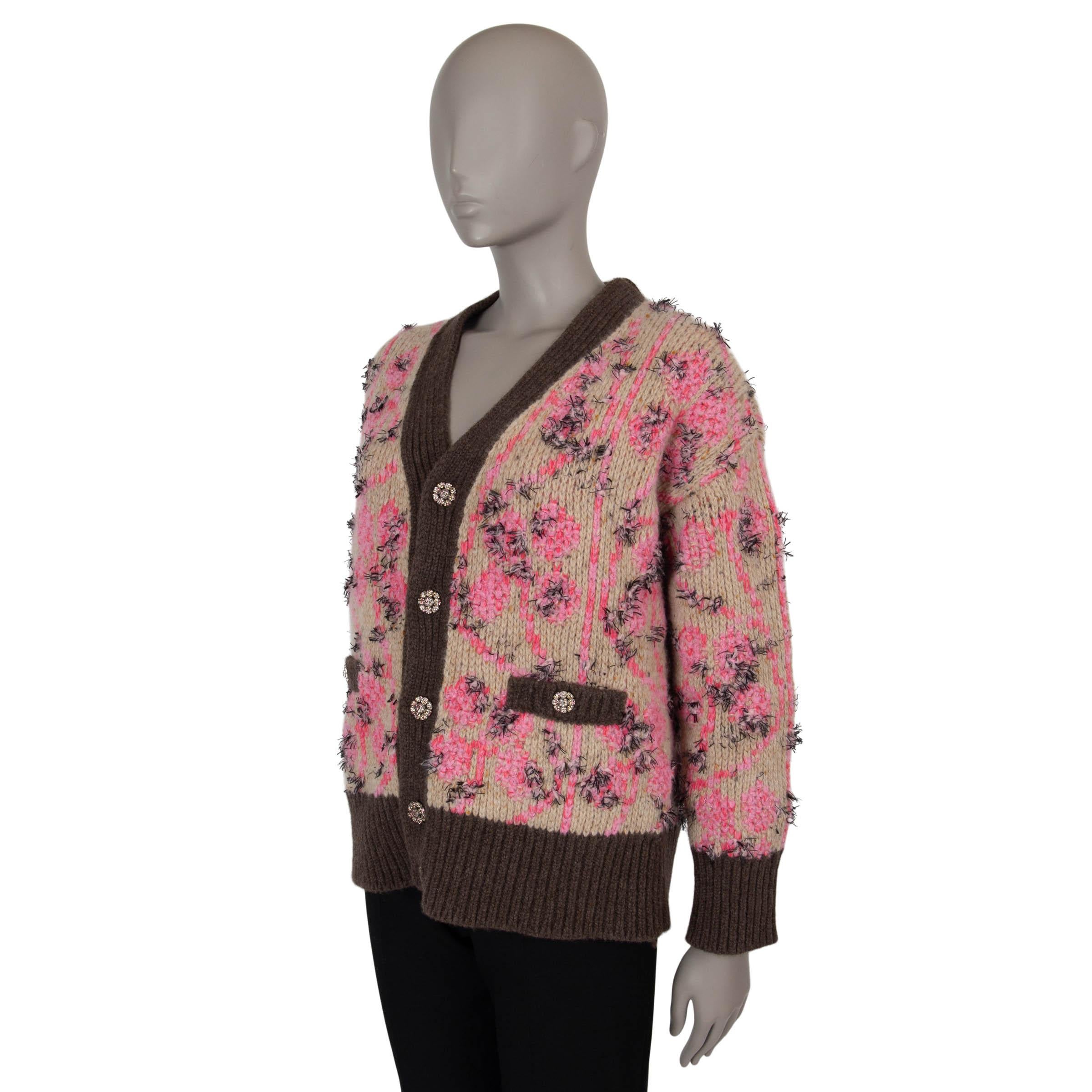 This 100% authentic Chanel knit jacket in beige and pink floral jacquard knit cashmere (63%), wool (25%), polyester (9%) and polyamide (3%) showcases a luxurious blend of texture and elegance. Adorned with fringe detailing, it features an oversized