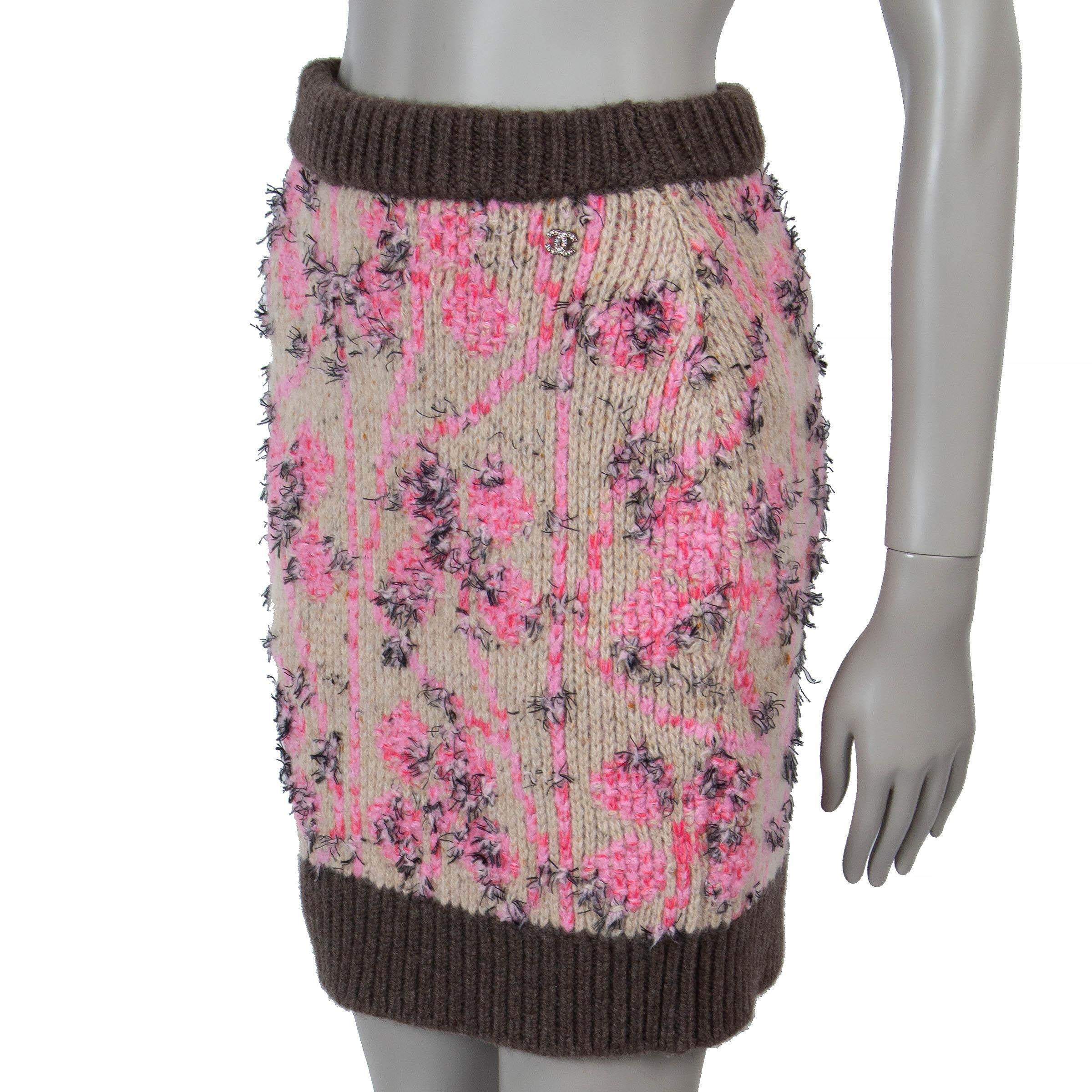 This 100% authentic Chanel knit mini skirt in beige and pink floral jacquard knit cashmere (63%), wool (25%), polyester (9%), and polyamide (3%) is a refined statement piece adorned with fringe. Featuring a straight silhouette, it is detailed with a