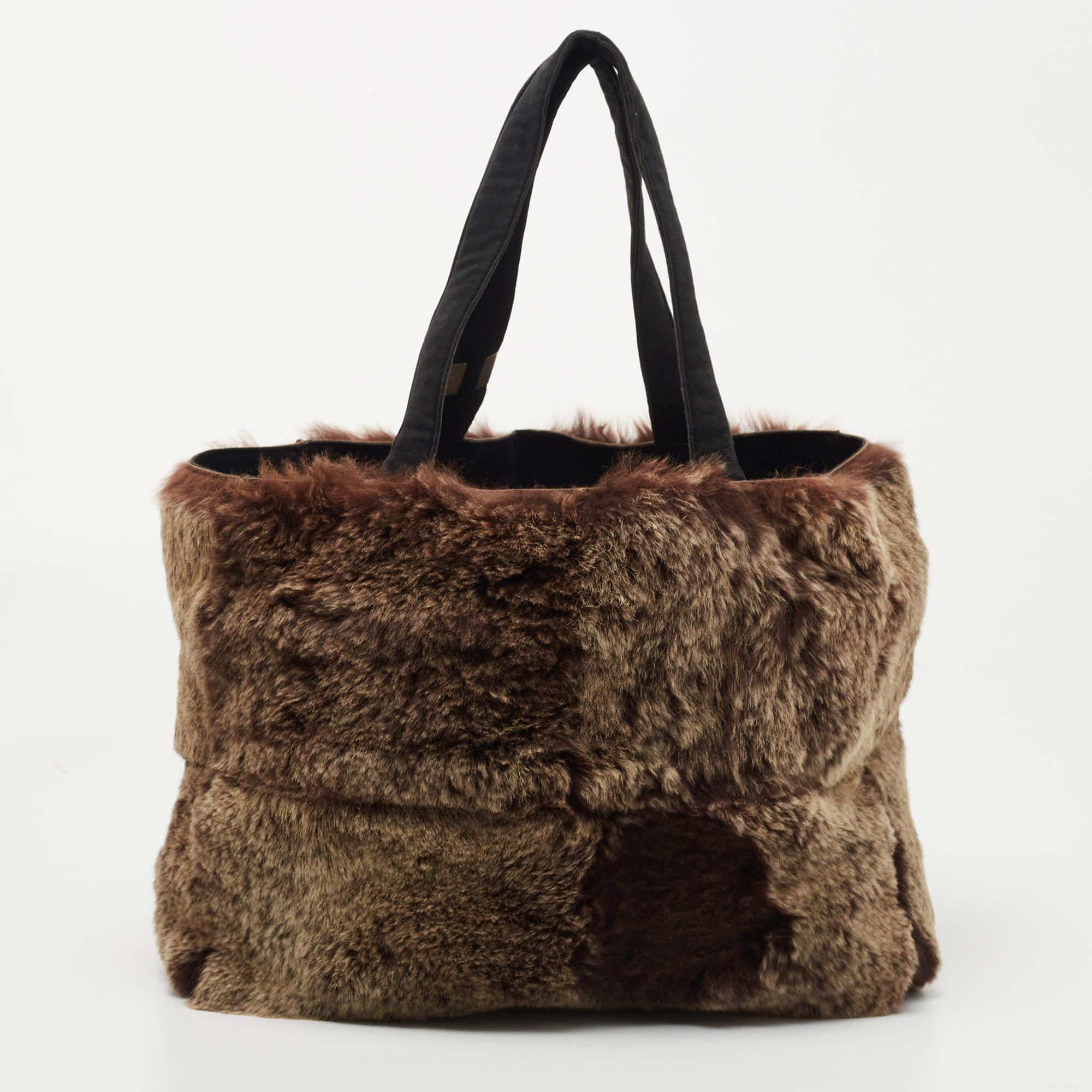 Carry everything you need in style thanks to this authentic Chanel tote. Crafted from rabbit fur and suede, it features flat handles and a nylon-lined interior.

