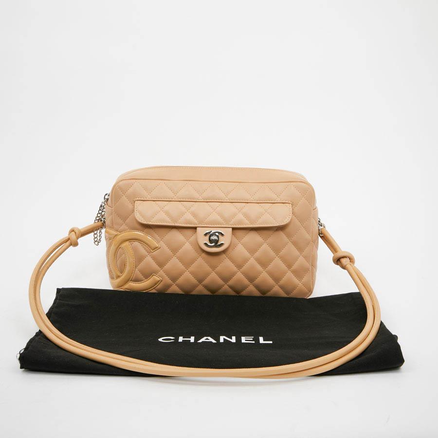 A great classic from Maison CHANEL, this camera bag is in beige quilted lambskin. The jewelry is palladium silver. On the front a 