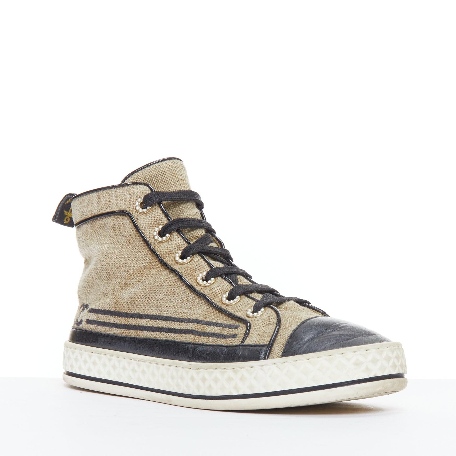 CHANEL beige canvas black CC logo pearl high top sneakers EU38
Reference: JACG/A00187
Brand: Chanel
Material: Canvas, Leather
Color: Black, Beige
Pattern: Solid
Closure: Lace Up
Lining: Nude Leather
Extra Details: CC logo at sides. Pearl