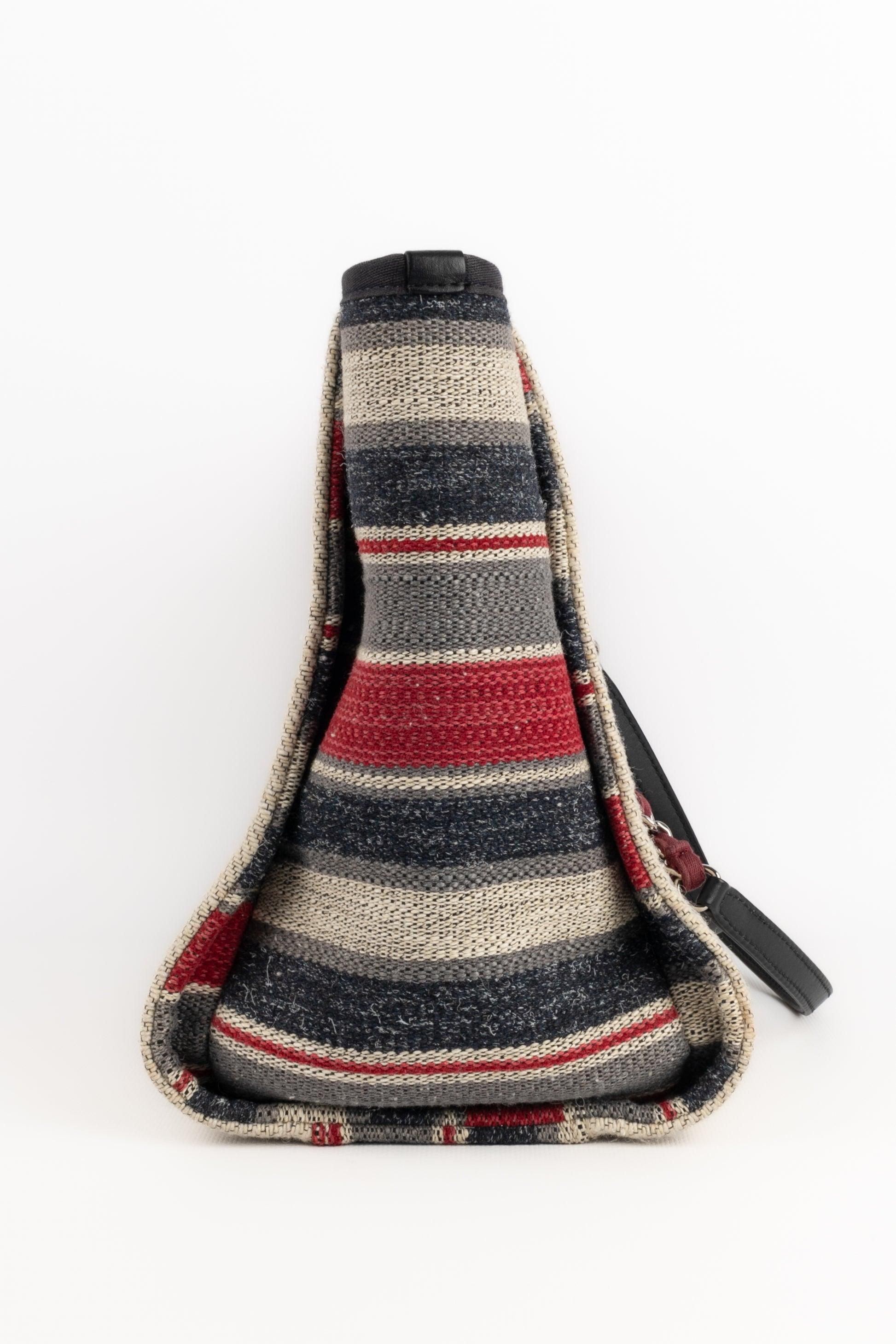 Chanel - (Made in Italy) Beige canvas 'Deauville' bag partially striped in red and grey; and with navy-blue leather. Magnetic snap fastener. A 2018 Collection, under the artistic direction of Karl Lagerfeld.

Additional information:
Condition: Good